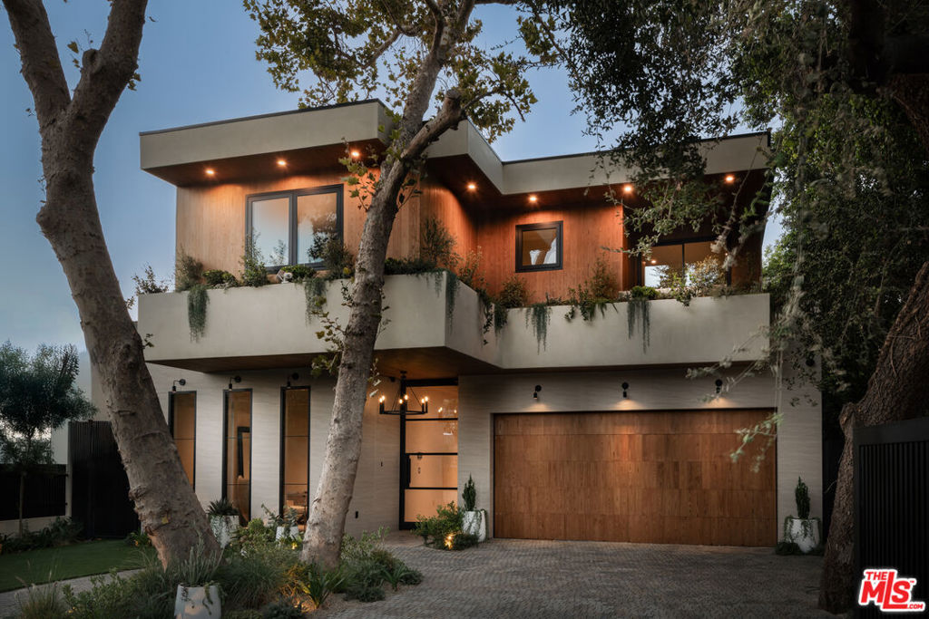 A stunning warm modern gated home, beautifully embraced by lush greenery offering the perfect blend of contemporary design and natural serenity. The architecture showcases clean lines, rich wood accents, and expansive glass windows that frame the surrounding landscape while inviting in natural light. Verdant planters and balconies lined with greenery create a seamless connection between indoors and out, enhancing the home's tranquil, organic appeal. The main home features 5 spacious bedrooms and 4.5 baths, designed with warmth, sophistication, and functionality. A detached two-story ADU adds 1 bedroom and 1.5 baths, ideal for guests, extended family, or private office use. This property is built for both relaxation and entertaining, complete with a sparkling pool and spa, multiple expansive balconies, and two sleek electric fireplaces in the living and family rooms. Altogether, the main residence spans 3,103 sq. ft., complemented by a 776 sq. ft. ADU and a 430 sq. ft. garage. Surrounded by nature yet infused with modern design, this home is a rare retreat that perfectly balances style, comfort, and greenery-filled serenity. Located in one of Sherman Oaks' most desirable pockets, just minutes from Ventura Blvd's premier dining, shopping, and entertainment. ADU under SB9 two-story two-unit developments.