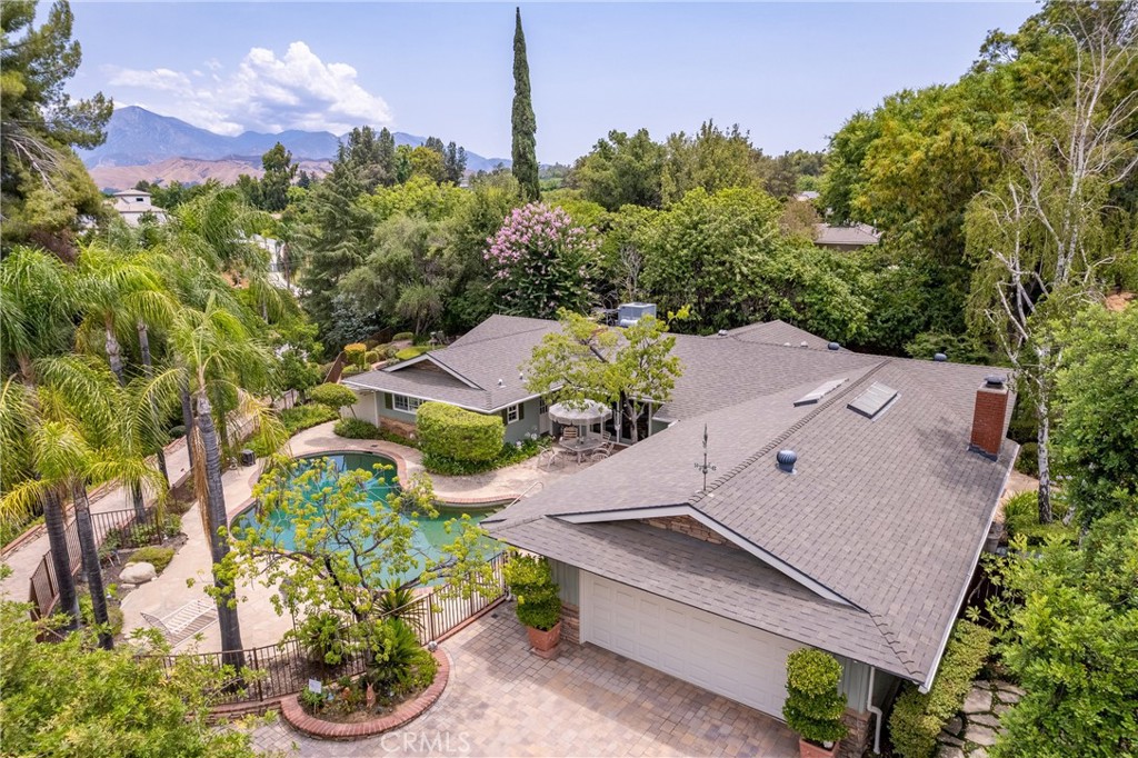 STUNNING CUSTOM-BUILT HOME with POOL-TENNIS & PICKLEBALL COURT Turnkey, single story located in Southeast Redlands. POOL HOME on nearly an acre. PRIVACY is all yours on TOP OF THE HILL. You will LOVE the LUSCIOUS LANDSCAPING and gorgeous paver driveway that wraps up to a large parking area with a two-car garage, surrounded by mature trees (some fruit). Magnificent views with a tennis & pickle ball court that completes the luxurious feel of this quiet and secluded home which is less than ten minutes from downtown Redlands and I-10. Custom floor plan has it all. Formal living room with vaulted ceilings, a family room with sliders open directly to the pool and leads straight into a spacious kitchen with natural light from a large garden window, and Formal dining room. As you would expect, the large primary suite includes a sliding glass door to the outdoor back patio. The other three bedrooms are perfectly located on the other side of the house, with two full baths. Redlands schools have high ratings.