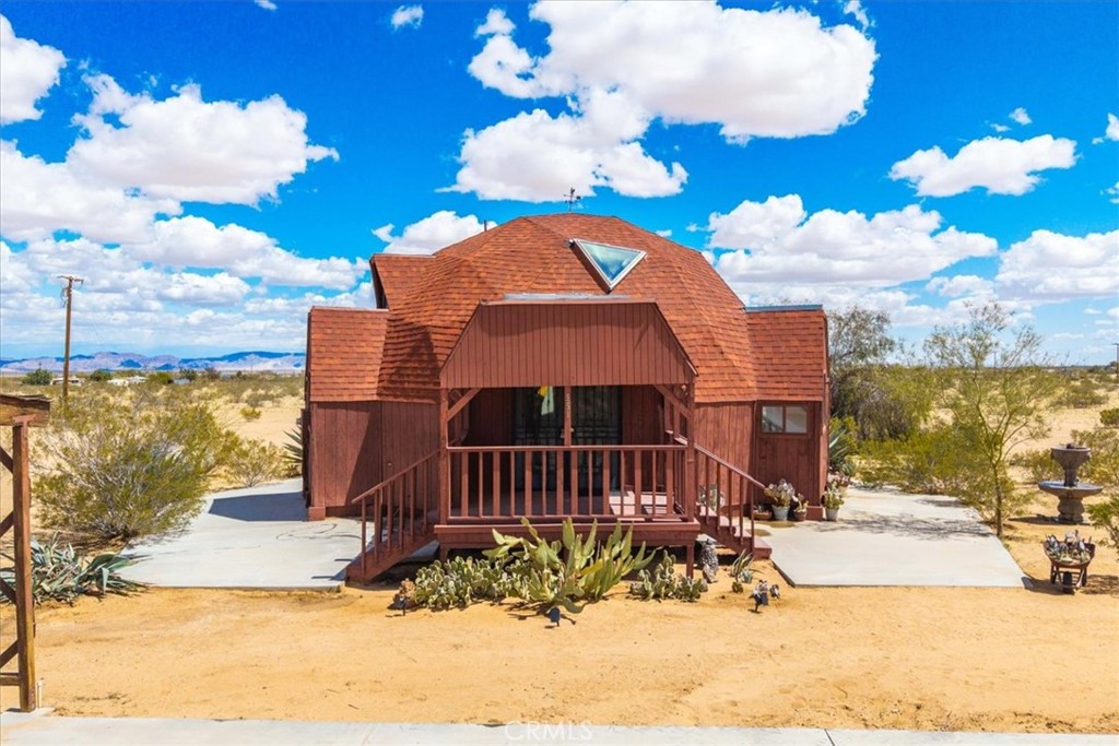 *PRICE REDUCED* Welcome to 951 N Kuna Ave, a beautiful and unique Desert Dome House nicely situated on a Corner Lot with 2.5 ACRES OF LAND surrounded by stunning desert & mountain views. As you step inside the freshly painted, bright & airy living space you'll find vaulted ceilings, multiple storage closets, brand new wood-like laminate flooring and several windows that let in an abundance of natural light. Just off the living room is the formal dining area which flows effortlessly into the kitchen space complete with warm wood cabinetry and a picture window above the sink to take in the gorgeous desert views. Downstairs you'll find 2 bedrooms with brand new carpet and ceiling fans, a shared bathroom with a shower/tub combo and a convenient in-door laundry room with washer/dryer hookups, storage shelves and a utility sink. Upstairs adorns the primary bedroom with an ensuite bathroom and a bonus living space that would make for a charming sitting area/reading nook, office or play space. That's just the inside! Outside you'll be delighted to find a fully fenced yard with a lovely front porch patio, natural desert landscaping, a large storage shed & carport and plenty of space to entertain or relax around a firepit on a starry desert night. It is desirably located close to numerous desert attractions like Lander's famous Goat Mountain hiking trails, Giant Rock, La Copine, The Integratron, and only 15 mins from downtown Joshua Tree but still far enough away to fully immerse yourself in all the beauty this peaceful and serene desert home has to offer. Come take a look and let this home's calming and captivating allure do the rest. Your new desert home or weekend retreat awaits!