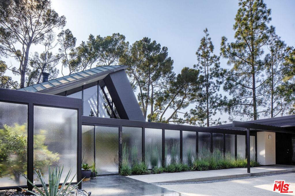 The iconic "Steel and Glass House" is a masterwork Designed by acclaimed modernist architect A. Quincy Jones and is restored to its original brilliance and tailored for refined contemporary living. Privately tucked at the end of a quiet cul-de-sac, the home commands breathtaking panoramic views of the Rose Bowl, JPL, Brookside Golf Course, and the Pasadena skyline from nearly every room. A fluid harmony between structure and landscape defines the experience. Inside, soaring 35-foot ceilings and walls of glass bring an abundance of natural light and architectural drama. A dynamic interplay of lines and angles creates both visual interest and serene openness. The expansive main level is designed for both grand entertaining and intimate moments, centered around a luminous dining area. Multiple lounge spaces offer uninterrupted views that serve as living art. The chef's kitchen features high-end Wolf and Sub Zero appliances with meticulously restored original cabinetry. In a private wing, the stylish primary suite offers its own balcony, en-suite bath, and inspiring views. Throughout the home, glass-walled hallways, tranquil gardens, and a dramatic waterfall into an indoor koi pond add to the spiritual experience. Ideally located just minutes from Pasadena's top dining, shopping, and cultural destinations, this rare offering is more than a home, it's a piece of architectural history ready to be personalized with your art collection. There is no mansion tax in Pasadena. Curated furniture may be included.