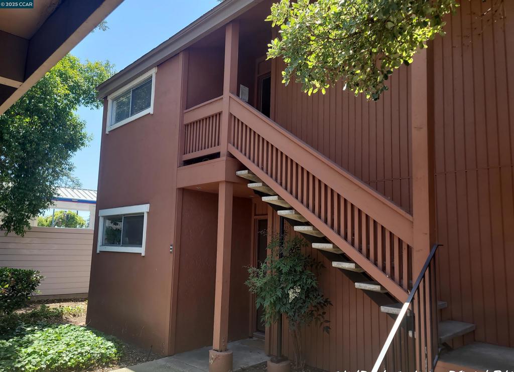 Located near the Walnut Creek border, this modern and spacious upper-level end unit offers over 800 square feet of comfortable, stylish living. Featuring 1 bedroom and 1 bathroom, the home boasts soaring vaulted ceilings, a cozy gas fireplace, and a charming step-down living room that opens to a formal dining area. The updated kitchen is equipped with contemporary appliances, solid stone countertops, and ample cabinet space to meet all your culinary needs. The generous bedroom includes a large closet for easy organization, while the private balcony offers additional outdoor storage and a peaceful space to unwind. A secure, shared community laundry facility is conveniently located in a nearby detached structure. Carport parking is included. Ideally situated close to shopping, dining, and transportation—just minutes from Costco, Trader Joe’s, Peet’s Coffee, Pleasant Hill BART, and more—this is the perfect blend of convenience and lifestyle.