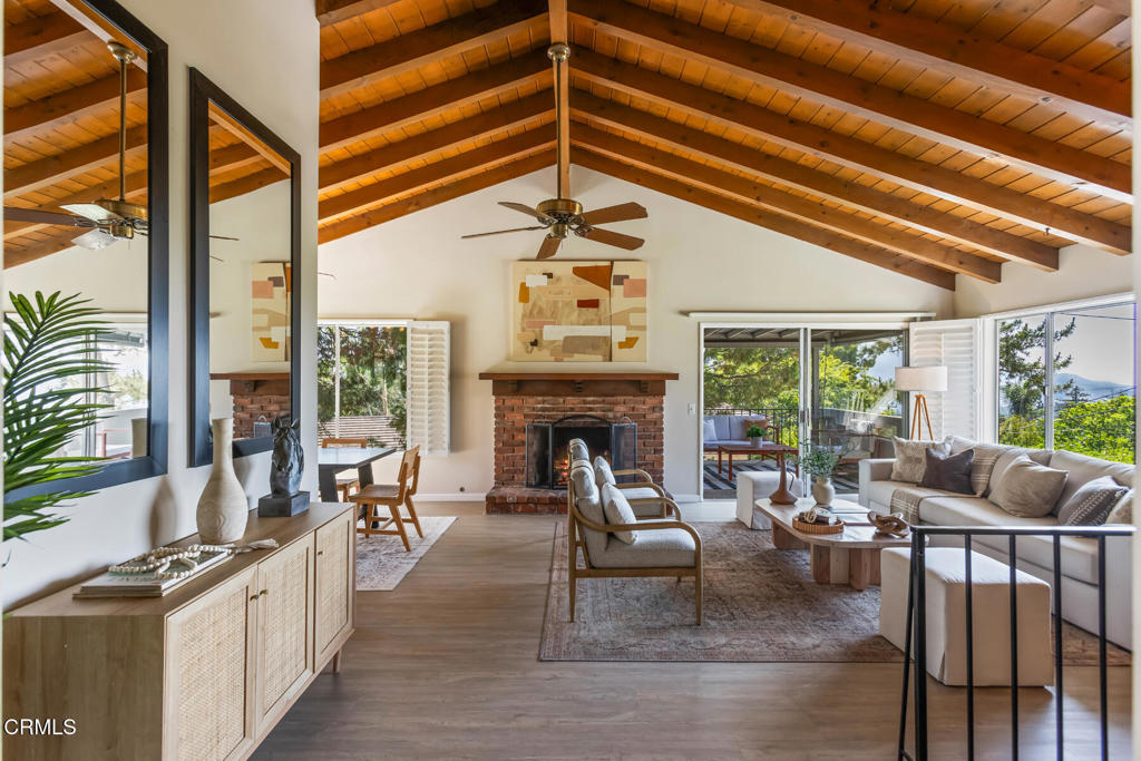 Tucked away at the end of a private driveway on a generous parcel surrounded by lush, mature greenery, this inviting 4-bedroom split-level ranch is move-in ready yet rich with potential for updates and reimagining. A gently winding front walkway leads through the garden, setting a warm and welcoming tone. Beyond the double doors, you are greeted by a beautiful exposed brick entryway that adds warmth and character, leading into a bright, airy living room with exposed wood-beam ceilings and a classic brick fireplace. A sliding glass door reveals a tranquil balcony patio with picturesque treetop and mountain views, perfect for morning coffee or evening relaxation. The open living area flows seamlessly into the dining room and a spacious kitchen offering abundant counter space, ample cabinetry, and a cozy breakfast nook with direct access to the backyard. Down the hall, the private bedroom wing includes four generously sized bedrooms and a full hallway bath. At the end, the primary suite serves as a true retreat with a large ensuite bath, vanity area, and direct access to its own charming private patio. The lower level features a versatile family room ideal for casual gatherings, with sliding glass doors opening to an additional patio that blends indoor comfort with outdoor living. Outside, multiple patios and seating areas provide flexible spaces to relax or entertain, all surrounded by privacy and greenery. Additional highlights include brand-new laminate flooring throughout the bedrooms, kitchen, and living space; central AC & heat; ceiling fans; direct access to a two-car garage with storage and workbench; a lower-level storage room; laundry closet; and plantation shutters throughout. The functional layout pairs beautifully with a backyard ready for your vision--whether that's a vibrant garden, expansive entertaining space, or the addition of an ADU, swimming pool, or sport court. All this is set within the award-winning La Crescenta school district, just up the street from Crescenta Valley High School.