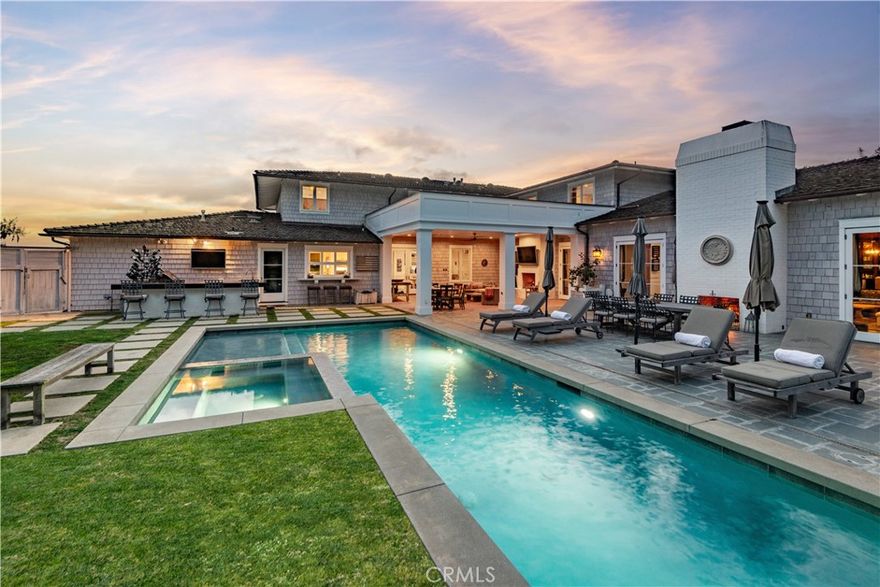 Designed in the spirit of the iconic “Shutters on the Beach” Hotel, this impressive Resort Point residence sits on a sprawling corner lot with unobstructed ocean views.  Soaring 9-foot ceilings and oversized rooms create a remarkable sense of volume, while slate and IPE wood floors, paneled walls, and French doors with integrated shutters add timeless charm. A gracious entry opens to the stunning living room with fireplace on one side and the kitchen with adjacent great room on the other. Anchored by a dramatic 10-foot L-shaped island, the kitchen features marble counters, stainless appliances, and sweeping ocean vistas. The entry level also includes an office, a large formal dining room, and a private guest suite with full bath. The massive family room with wet bar, wine closet, fireplace, and soaring ceilings leads to an amazing 12-seat theater making movie nights and sporting events unforgettable. Upstairs, five spacious bedrooms include a tremendous primary suite with breathtaking views.

The outdoors is an entertainer’s paradise. The expansive, hedge-lined front lawn features a fire pit that’s perfect for sunset gatherings, while the private backyard is highlighted by a 50-foot lap pool with spa and Baja shelf, a multi-sport court (pickleball, paddle tennis, volleyball, basketball), an outdoor kitchen with Hestan BBQ as well as a TV to keep the grill chef happy!  The 600-square-foot loggia has built-in heaters, fireplace, and a big screen TV that ensures year-round enjoyment.

Additional amenities include a Lutron lighting system with programmable scenes, security with cameras and recording, air conditioning, two laundry rooms, and a 3-car garage with EV charging.