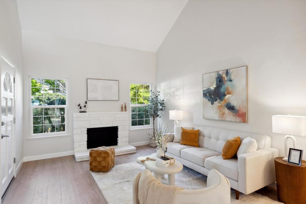 Beautifully updated throughout, this Bay Vista townhouse offers high ceilings, generous natural light, and flexible spaces for modern living. From the footpath lined with roses, step through a hedge-lined walkway to your dedicated front porch, an inviting blank canvas for relaxing or greeting guests. Inside, the living room features soaring double-height ceilings, new luxury vinyl plank flooring, and a white washed wood-burning fireplace while windows surrounding the fireplace provide ample natural light. A flexible den with double doors makes an ideal office or optional third bedroom, and a half bath around the corner adds flexibility. The updated kitchen features quartz countertops, shaker cabinetry, a deep stainless steel sink, and stainless appliances. Upstairs, the carpeted landing overlooks the living room and includes a built-in storage nook. The primary suite offers high ceilings and backyard views with a sleek updated ensuite, while the secondary bedroom faces the roses and streetscape. A renovated full hall bath serves the additional bedroom and guests. Includes two dedicated outdoor spaces and a detached two-car garage. Enjoy unbeatable access to community amenities like a pool, clubhouse, greenbelts, and nearby public parks, trails, top schools, and shopping.