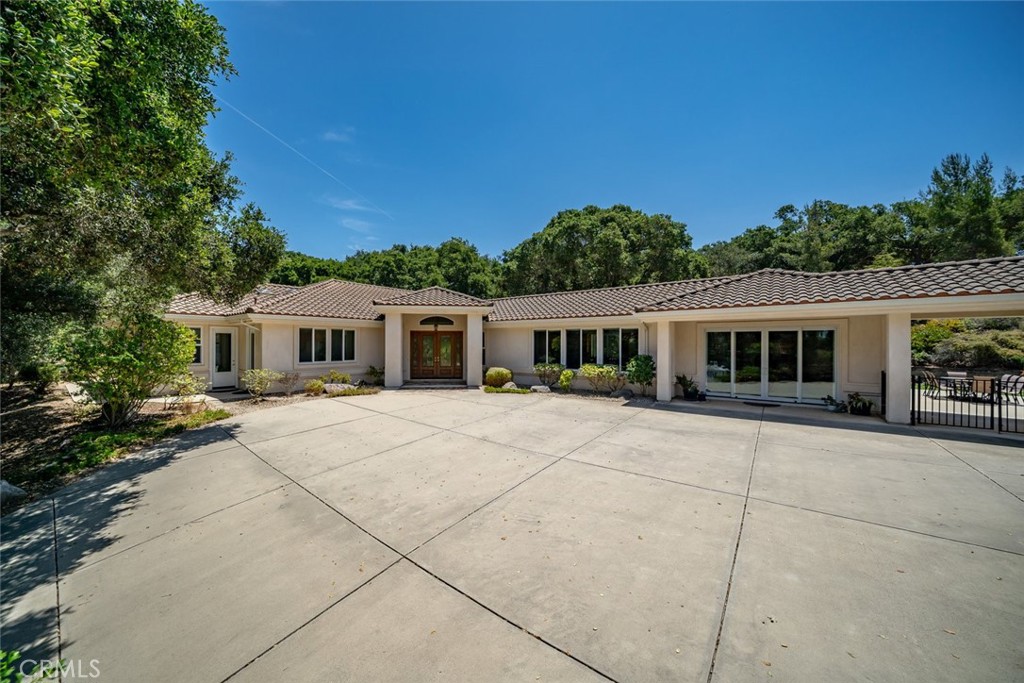 Welcome to 615 Sweet Donna Place, a truly exceptional custom estate nestled on nearly two private, oak-studded acres in the heart of Nipomo. From the moment you arrive, a dramatic two-lane driveway lined with majestic oak trees invites you into a peaceful world of timeless elegance and refined living.
Built in 2003 and impeccably maintained by its original owner, this thoughtfully designed single-level home offers 3255 square feet of flexible living space, including four spacious bedrooms and three and a half bathrooms. The versatile fourth bedroom, with its own private exterior entrance, is ideal for guests, a home office, or a secluded retreat with a separate entrance. At the heart of the home is a chef-inspired kitchen and family room, crafted for those who love to cook, gather, and entertain. The expansive granite island includes a secondary prep sink, high-arc pot-filler faucet, and custom pull-out cabinetry for cookware. Premium appliances—such as a built-in refrigerator, Bosch dishwasher, and electric range (with a capped gas line for easy conversion)—make everyday living and hosting effortless. Adjacent, the cozy family room features a custom fireplace and built-ins, all flowing seamlessly to the outdoor entertaining areas. The formal living and dining rooms offer elevated spaces for special occasions, while the open-concept layout ensures comfort and connectivity throughout. The primary suite is a tranquil haven, complete with a large walk-in closet and a luxurious en-suite bath featuring dual vanities, a skylight, soaking tub, and separate shower. Set in a serene, park-like setting with mature landscaping, this estate balances privacy and prestige with warmth and versatility. Every inch reflects quality craftsmanship, custom details, and pride of ownership. Additional features include: an oversized 3-car garage with ample storage, an Indoor laundry room with a sink and cabinetry, and an expansive outdoor space with room to personalize. Ideal location with easy access to Central Coast wineries, beaches, and golf. This one-of-a-kind estate offers an unparalleled lifestyle opportunity in one of Nipomo’s most desirable areas. Come experience the grace, space, and soul of 615 Sweet Donna for yourself—schedule your private showing today.