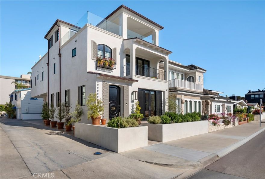 Welcome to 318 Coronado Street, a stunning custom-built 3-bedroom, 5-bathroom home located just two doors from the bay on the coveted Balboa Peninsula. This elevated corner residence offers panoramic views of the Newport Harbor, abundant indoor/outdoor living space, three-car parking (two-car garage plus an oversized carport), and a private elevator serving all three levels. The main level features a gourmet kitchen with a large island and high-end appliances, and a large great room that flows seamlessly out to a spacious front patio with bay views. A custom metal spiral staircase—paired with the elevator—leads to the second level with two guest suites, a laundry room, and a luxurious primary suite which includes a private balcony, dual vanities, soaking tub inside a walk-in shower, and a large walk-in closet. The show-stopping rooftop deck on the third floor spans two outdoor living areas: one with covered seating, a fireplace, TV, and wet bar, and the other with open-air lounging and views stretching from the ocean to Fashion Island - all perfect for al fresco dining and entertaining. This thoughtfully designed home blends refined craftsmanship with effortless beach living in one of Newport Beach’s most desirable locations.