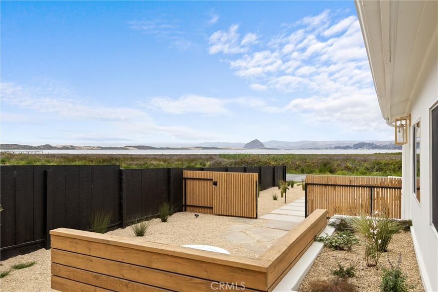 This beautifully reimagined and fully renovated coastal retreat offers effortless single-level living with forever-protected, sweeping views of iconic Morro Rock, the bay, the dunes, and the distant hills of Cayucos and Morro Bay, all visible from the main living spaces, primary suite, and upstairs guest bedroom. From inside and out, take in the peaceful panorama while enjoying the soothing sound of the ocean carried in on the breeze.  Spanning approximately 1,800 sq. ft., this 3-bedroom, 3-bath home blends thoughtful design with premium craftsmanship. White oak hardwood flooring runs throughout, complemented by recessed lighting, solid core wood doors, fluted bathroom detailing, and high-end finishes including Kohler fixtures in the bathroom, Brizo fixtures in the kitchen, and designer hardware. The open-concept kitchen is a showpiece with custom white oak cabinetry and island with storage, striking Taj Mahal quartzite countertops and backsplash, and high-end appliances seamlessly integrated for both style and performance.  The light-filled primary suite opens through French doors to the beautifully landscaped front yard, where panoramic views of the Rock, dunes, and bay provide a stunning backdrop. Inside, the spa-like en-suite features a freestanding tub, walk-in shower with a Kohler Anthem system, dual closets, dual vanities, a private water closet, and a serene garden-view window.  Each guest bedroom offers comfort and privacy, one with an en-suite bath on the lower level, and the other upstairs with sweeping Rock and bay views plus a private rear deck overlooking the hills.  Step outside to enjoy professionally designed landscaping with automatic irrigation and accent lighting. A DG semi-circular drive offers additional parking, while flagstone pathways guide you through the front yard to a modern steel-framed vertical fence that encloses a gated garden—an inviting outdoor space with built-in bench seating and a fire pit. The fully fenced backyard features more flagstone paths, a detached, finished 224 sq. ft. casita (included in the total square footage) ideal for guests, a home office, or studio, a powered storage shed with recessed lighting, and room for RV parking or future enhancements.  Located in Cuesta by the Sea, just a block from Sweet Springs Nature Preserve and close to Baywood, Sea Pines Golf Resort, Montana de Oro, Morro Bay, and San Luis Obispo.