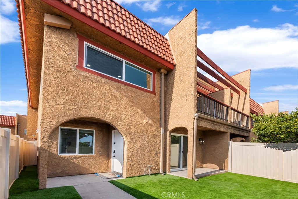 Bright, fully renovated end-unit townhome with a private yard, balcony, and 2-car garage. This 3-bed, 2.5-bath layout features an open main level with wide-plank flooring, recessed lighting, and a modern tiled fireplace. The new kitchen showcases white shaker cabinetry, quartz-style counters, subway backsplash, open wood shelving, matte-black fixtures, and a stainless appliance suite. Sliders open to a fully fenced turf yard for easy indoor/outdoor living. Upstairs are three generous bedrooms; the expansive primary offers wall-to-wall closets and a private balcony. All baths are new with coordinating vanities, quartz tops, matte-black hardware, and marble-look tub/shower tile. End-unit positioning adds extra light and privacy. Convenient location close to everyday shopping and dining with quick freeway access—minutes to Disneyland, Angel Stadium, parks, and area beaches.