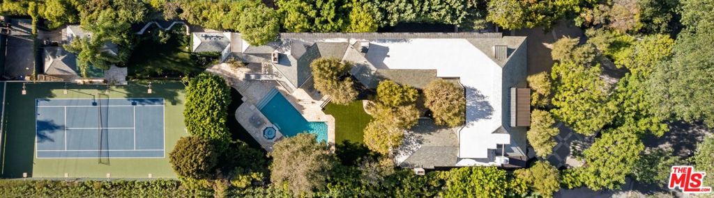 Stunning tennis court estate set in the highly sought-after Beverly Hills Flats. This approx 13,600 SF estate sits on almost an acre lot and is behind a gated motor court and lush greenery to provide the utmost privacy. Enter to a grand foyer with soaring ceilings and beautiful finishes throughout. The double height formal living room has floor-to-ceiling windows that allow natural light to fill the home. Kitchen offers high-end appliances, oversized island, and breakfast area. Spacious primary suite offers fireplace, private balcony, dual bathrooms, walk-in closet, and wet bar area. 7 additional ensuite bedrooms provide ample space. Resort-like grounds offer large pool, spa with waterfall, built-in BBQ, large flat lawn, expansive patio, and night-lit tennis court. A detached guest house sits next to the tennis court and is the perfect place to relax after a match. Make this incredible estate your home and live moments from the best dining and shopping that Beverly Hills has to offer. Viewings by appointment only. Call agents for a private showing.