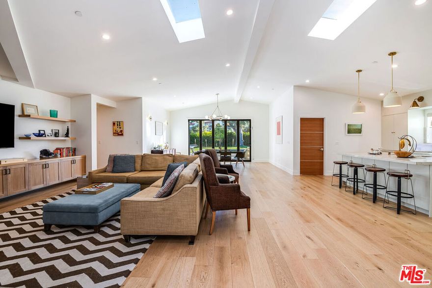 Welcome to this beautifully reimagined home, set on a renowned jacaranda-lined street in one of Sherman Oaks' most sought-after neighborhoods. Sitting on an expansive 9,500+ sq. ft. lot, this 5BD/4BA residence was completely rebuilt in 2024 with meticulous attention to detail.Inside, elegant white oak floors, soaring 12-foot vaulted ceilings, custom cabinetry, and two oversized skylights create an airy, light-filled atmosphere. The chef's kitchen features luxury appliances, a walk-in pantry, abundant storage, and a striking center island, seamlessly connecting to the main living area. Accordion glass doors open wide to the backyard, blending indoor and outdoor living.The primary suite offers a spacious walk-in closet and a spa-like en suite with a double vanity, freestanding soaking tub, and terrazzo floors.The resort-style backyard is an entertainer's dream with a custom BBQ station, sparkling pool, spa, and ample space for gatherings.Perfectly located within the highly coveted Dixie Canyon Community Charter Elementary district and just minutes from The Shops at Sportsmen's Lodge, Casa Vega, and Ventura Blvd dining, this home is the ultimate blend of comfort, convenience, and California living.