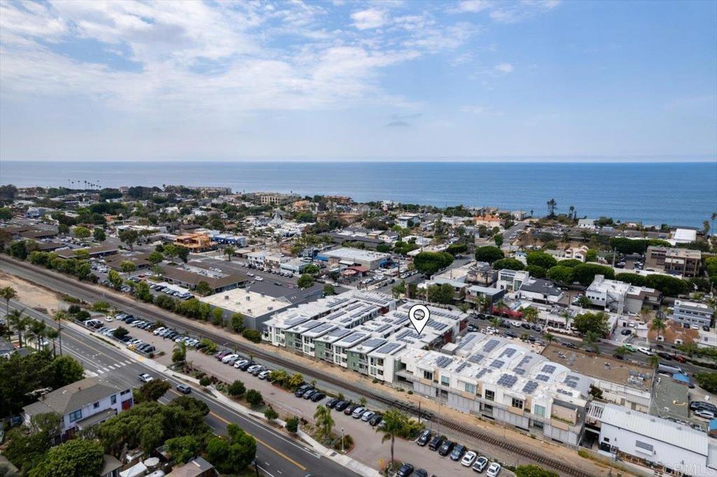 Experience the perfect fusion of beach town charm and modern luxury at this exceptional Pacific Station residence, nestled in the vibrant heart of downtown Encinitas. Just steps from renowned surf spots, boutique shopping, acclaimed eateries, and lively entertainment, this home offers an unmatched coastal lifestyle where the best of Southern California is right at your doorstep. Designed for refined living and comfort, this two-story home boasts high-end finishes and thoughtful upgrades throughout. Newly remodeled with all-new LVP floors, a kitchen that features new premium appliances, new track lighting, and new hardware, spacious counters with ample countertop seating, a walk-in pantry, and an open flow to the cozy family room—perfect for entertaining or quiet evenings. The private patio invites the ocean breeze and offers a relaxing escape. The spacious primary suite is one of three bedrooms, and is a serene retreat complete with an accent wall, a private balcony, a generous walk-in closet, and an en suite bathroom with a dual-sink vanity and a shower/tub combo. A second bedroom with an en suite full bath offers comfort and privacy, and a third bedroom on the first floor, currently staged as a home office, adds flexibility to suit your lifestyle. A stylish powder room is conveniently located for guests. The bathrooms feature new hardware and new shower valves, enhancing each bath's functionality and style. Set within Pacific Station, this exclusive complex offers a private community patio with a cozy fireplace, lounge seating, and a barbecue area, all set back from Highway 101—providing both privacy and proximity to the best of Encinitas. Lush succulents and meticulously maintained landscaping create a warm and inviting ambiance throughout. Additional features include a secure underground parking structure with two tandem spaces and an adjacent storage cage. With the Coaster and Amtrak station just one block away, commuting to downtown San Diego is effortless, making this home the epitome of coastal convenience and elevated living. Your dream beachside lifestyle starts here.
