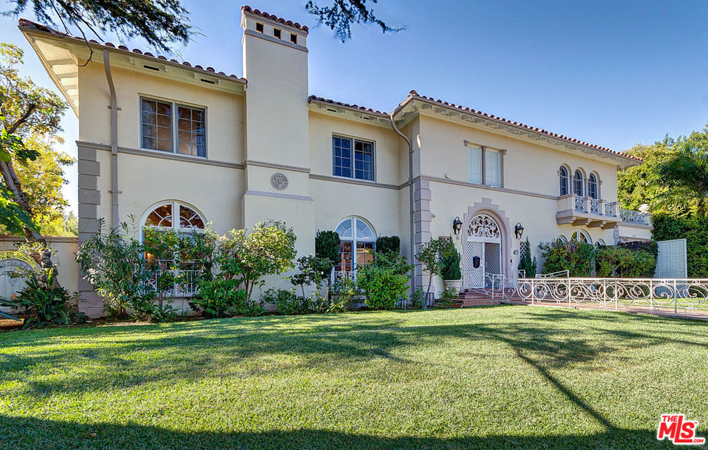 This breathtaking estate takes you back to the Golden Age Hollywood glamour with much modern appeal. This fabulous property is situated on one of Hancock Park's most beautiful and prestigious streets. This home boasts a magnificent 2-story foyer with a grand crystal chandelier and a wide circular staircase. An open layout with splendid entertaining rooms, consisting of an enormous living room with an elegant fireplace, family room with garden views, dining room with exquisite and original rich wood paneling and ornate ceiling moldings, a delightful sunroom and a formal study. The state-of-the-art remodeled chef's kitchen with center island and separate breakfast room is equipped with high-end appliances and offers abundant storage. There are 5 sun-filled bedrooms and 4 bathrooms, including a primary suite with a marble bath, a private balcony, and large custom closet. Step outside to a very private and verdant garden, with ample room for pool/spa. Additional 2 rooms with a bathroom and kitchenette and a garage with gated driveway. Many other features include 3 fireplaces, an elevator, security system, French doors and hardwood floors.