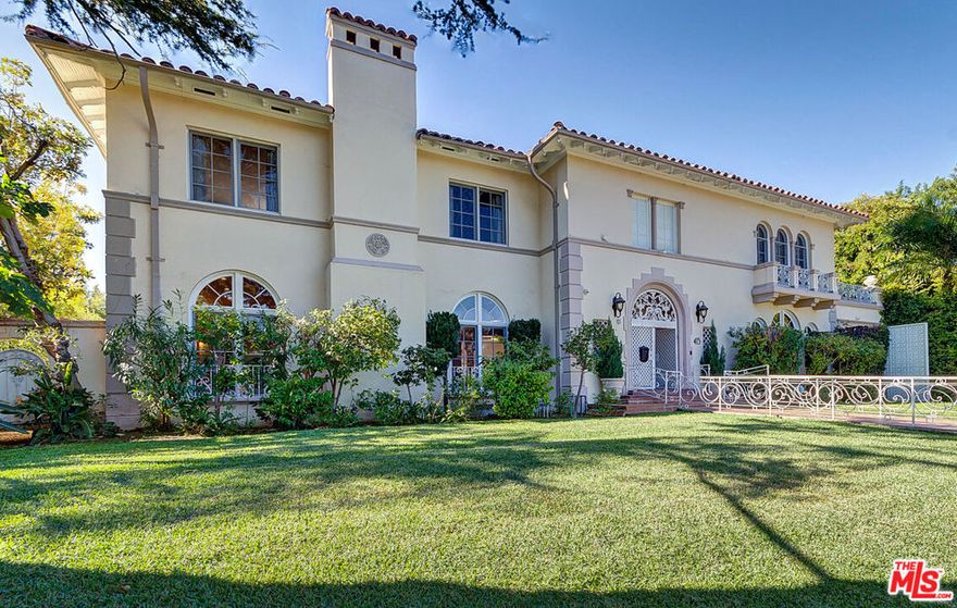 This breathtaking estate takes you back to the Golden Age Hollywood glamour with much modern appeal. This fabulous property is situated on one of Hancock Park's most beautiful and prestigious streets. This home boasts a magnificent 2-story foyer with a grand crystal chandelier and a wide circular staircase. An open layout with splendid entertaining rooms, consisting of an enormous living room with an elegant fireplace, family room with garden views, dining room with exquisite and original rich wood paneling and ornate ceiling moldings, a delightful sunroom and a formal study. The state-of-the-art remodeled chef's kitchen with center island and separate breakfast room is equipped with high-end appliances and offers abundant storage. There are 5 sun-filled bedrooms and 4 bathrooms, including a primary suite with a marble bath, a private balcony, and large custom closet. Step outside to a very private and verdant garden, with ample room for pool/spa. Additional 2 rooms with a bathroom and kitchenette and a garage with gated driveway. Many other features include 3 fireplaces, an elevator, security system, French doors and hardwood floors.