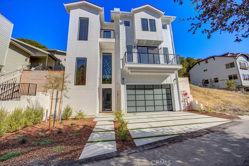 Nestled on a serene private street in Arroyo Grande’s coveted Village, this newly built home with a private elevator blends modern luxury and natural beauty, free from HOA. Set on a 9,164-square-foot lot amid coastal oaks, it offers stunning hill, creek, and valley views. The 2,484-square-foot residence features three spacious bedrooms, two full bathrooms, and a powder room. Its open layout showcases custom riff-sawn white oak flooring, marble bathrooms, countertops, and fireplace, plus premium fixtures. The gourmet kitchen with custom cabinetry flows into living and dining areas, perfect for entertaining. The master suite includes a large walk-in closet and spa-like bathroom. With over 800 square feet of garage and 200 square feet of storage, space abounds. Elegant concrete steps wrap from the side yard to the backyard. Two front decks provide prime views. Steps from the vibrant Village, enjoy shops, restaurants, wine tasting, and festivals. In the esteemed Lucia Mar Unified School District, it’s ideal for families. Discover refined living in this exceptional home.
