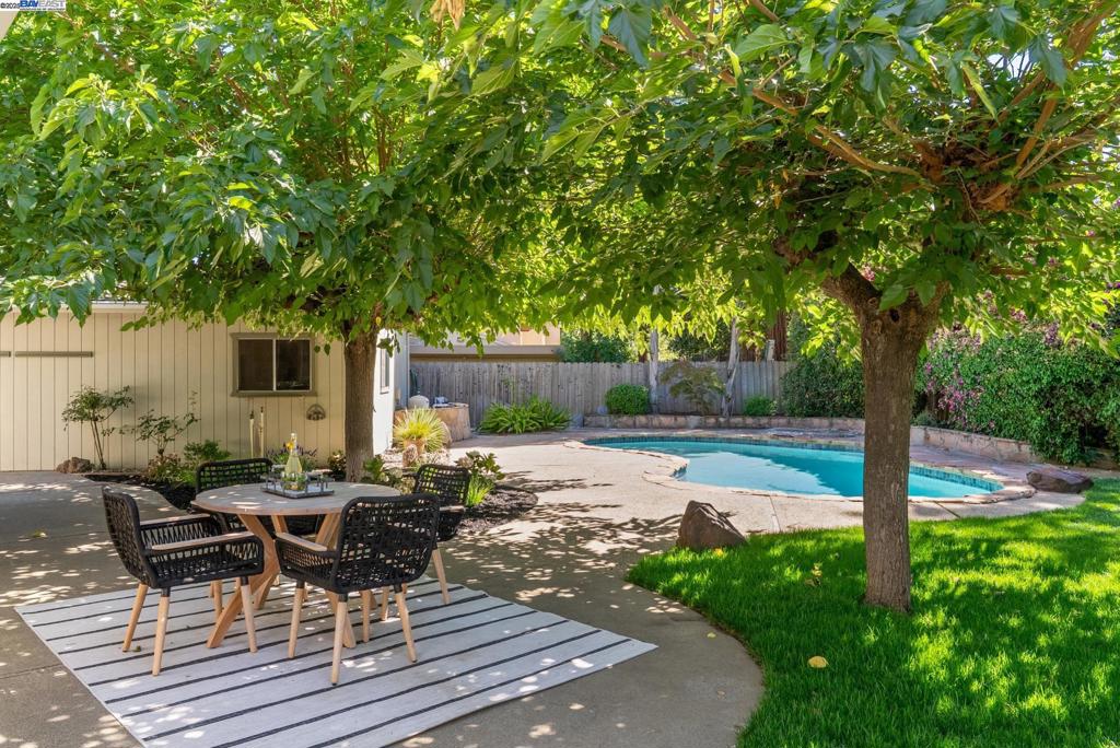 Discover the ultimate California lifestyle in this 4-bedroom, 2.5-bath home on a sprawling 0.34-acre flat lot with pool & spa. This property is a unique sanctuary designed for functionality, entertaining, and relaxation. Step inside to an interior featuring a formal living room with a fireplace and a separate family room. The updated chef's kitchen is the heart of the home, boasting granite counters, stainless steel appliances, a breakfast bar, and a pass-through window to an outdoor bar. Modern comforts are covered with a newer roof, dual-pane windows, central heat & air, and cost-saving leased solar. The backyard is an entertainer's dream where you can host parties on the expansive grounds, take a dip in the pool, or unwind in the spa located just outside the primary bedroom's slider. A dedicated raised garden bed awaits, with ample space to expand.The possibilities are endless with a 2-car attached garage PLUS a fully detached 2-car garage/workshop—a dream for any collector or hobbyist. Secure, double-gated access provides ample parking for your RV and boat. New interior painting, new light fixtures. Located near Concord BART, freeways, and the vibrant Todos Santos Plaza, this home blends private, resort-style living with city convenience. It's a lifestyle waiting for you.