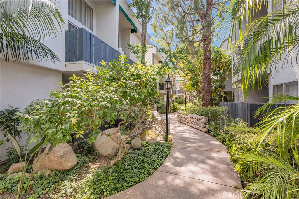 Welcome to this bright and modern 1-bedroom, 1-bath loft-style condominium located in the gated community of California Place. This unique two-level unit features soaring high ceilings and an open-concept layout that creates a spacious and airy atmosphere. The main bedroom and full bathroom are privately located on the upper level, with an open view overlooking the living and dining areas below, giving the home a stylish loft-like appeal. Carpeted stairs lead up to the second floor, where you’ll find the master bedroom, a generous closet and abundant natural light. Downstairs, dark laminate flooring adds a sleek, contemporary touch throughout the living and dining spaces. The kitchen is well-equipped with granite countertops, a stainless steel refrigerator and stove, and a white microwave—perfect for comfortable and functional everyday living. Step out onto your private balcony and unwind to the soothing sounds of a tranquil water feature just outside in the beautifully landscaped common area. This condo includes two assigned tandem parking spaces and access to a wide range of resort-style amenities, including a sparkling pool and spa, a clubhouse for social gatherings, a BBQ area, a fitness center, a sauna, and convenient on-site laundry facilities. Ideal for the first-time buyer ready to stop renting and start building their real estate portfolio, this home offers a rare combination of comfort, convenience, and community in one of the area's most sought-after gated neighborhoods.