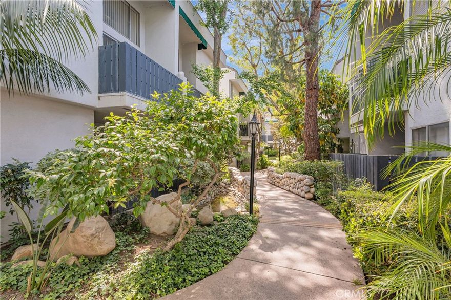 Welcome to this bright and modern 1-bedroom, 1-bath loft-style condominium located in the gated community of California Place. This unique two-level unit features soaring high ceilings and an open-concept layout that creates a spacious and airy atmosphere. The main bedroom and full bathroom are privately located on the upper level, with an open view overlooking the living and dining areas below, giving the home a stylish loft-like appeal. Carpeted stairs lead up to the second floor, where you’ll find the master bedroom, a generous closet and abundant natural light. Downstairs, dark laminate flooring adds a sleek, contemporary touch throughout the living and dining spaces. The kitchen is well-equipped with granite countertops, a stainless steel refrigerator and stove, and a white microwave—perfect for comfortable and functional everyday living. Step out onto your private balcony and unwind to the soothing sounds of a tranquil water feature just outside in the beautifully landscaped common area. This condo includes two assigned tandem parking spaces and access to a wide range of resort-style amenities, including a sparkling pool and spa, a clubhouse for social gatherings, a BBQ area, a fitness center, a sauna, and convenient on-site laundry facilities. Ideal for the first-time buyer ready to stop renting and start building their real estate portfolio, this home offers a rare combination of comfort, convenience, and community in one of the area's most sought-after gated neighborhoods.
