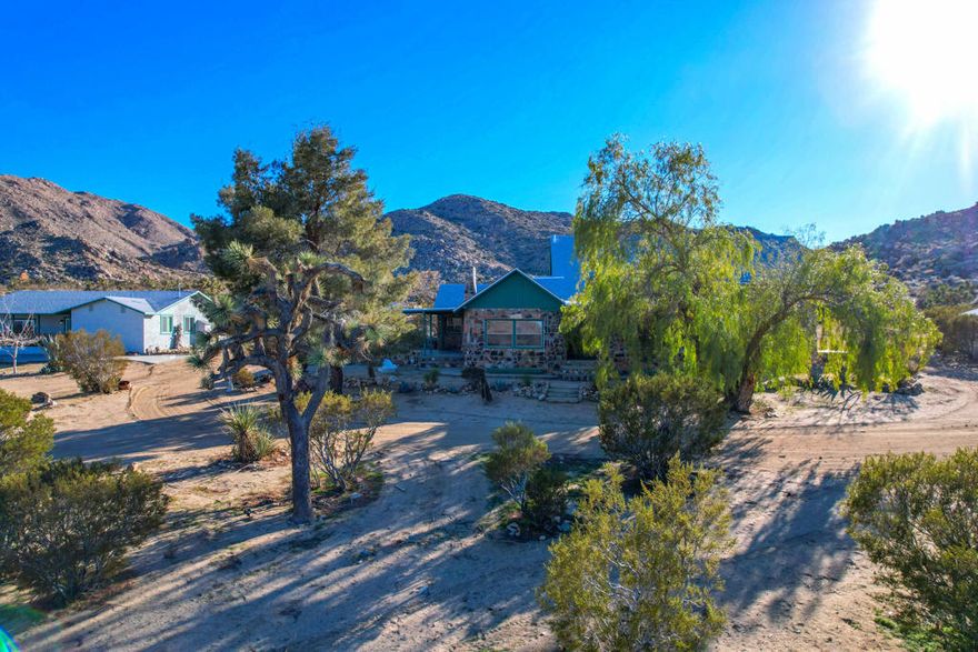 Welcome to the best kept secret in Joshua Tree, your own gated and fully fenced private oasis on 10 acres. This rare offering includes two separate 5-acre parcels, featuring two beautifully remodeled homes and a charming casita, all thoughtfully updated in 2022.In total, this extraordinary property offers 8 bedrooms + 1 loft + 5.5 bathrooms across three beautifully remodeled living spaces, providing versatile options for personal use, hosting, or income potential. This property is Ranch Ready! with 10 acres of open land and access to nearby riding trails, this property is perfect for horses, barns, or a custom equestrian setup. Plenty of space to build your dream ranch!Main House - known as the Mainstay- 3 bedrooms, 1 loft, and 2 full bathrooms, a state of the art kitchen and moreSecond Home - known as the Cowgirl- 4 bedrooms, 2 full bathrooms, and a half bathStudio Casita- known as the quiet Farm boy- 1-bedroom studio with Murphy bed and1 full bathroomAdditional highlights include leveled parking for up to 25 vehicles, designated walkways to each home, a large flat area ideal for yoga sessions, outdoor dining, or events, and a built-in fire pit for cozy evenings under the stars. Each structure features updated electrical panels prepped for solar installation, and the entire property is enclosed with 6-foot privacy fence, creating a secure and serene environment.Set amongst ancient boulders, iconic Joshua Trees, and surrounded by rocky hills, this serene and private property offers breathtaking views, vibrant sunrises, glowing sunsets, and star-filled night skies. To top it all off, there is 20 acres of protected BLM land in front of the property that can not be built on.  Honestly, the pictures and videos do not do it justice, this property is a must see to truly appreciate! This is a prime location just minutes from the Joshua Tree National Park, JT Village, restaurants, shopping, art galleries, schools, and medical facilities. Enjoy unmatched hiking, climbing, and nature experiences right at your doorstep.With gated privacy, exceptional views in every direction, and no light pollution, this property is perfect for investors, creatives, nature-lovers, and those seeking peace, beauty, and possibility.Don't miss this unique chance to own one of Joshua Tree's most iconic and versatile properties. The possibilities are endless - make it your private retreat, family compound, ranch haven or high-demand short-term rental.