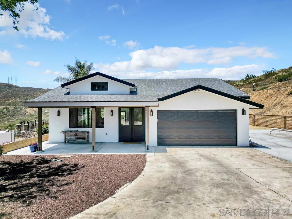 Discover a one-of-a-kind modern farmhouse nestled on 2.45 acres in Santee, offering the perfect blend of luxury, privacy, and convenience. This fully renovated single-story home spans 3,068 ft.² with 4 spacious bedrooms and 3 beautifully designed bathrooms. Tucked against miles of untouched open space, it feels like country living just minutes from city amenities. Soaring 10’-14’ ceilings, expansive black fiberglass windows, and glass doors flood the home with natural light and showcase sweeping views from Lakeside to Mt. Helix. No detail was spared—enjoy a chef’s kitchen with quartzite countertops, smart appliances, and designer lighting throughout. The home features whole-house smart systems, dual-zone HVAC, extensive insulation, and future-ready infrastructure for solar, EV charging, and a potential ADU or pool house. With a new septic system, copper plumbing, smart water heater, and more, this home is move-in ready and built for modern living. A rare opportunity in the heart of Santee.