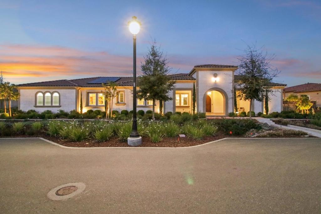 Set on a corner lot, this stunning 4,057 SF single-story home features the coveted Colline floor plan with 4 spacious bdrms, each w its own full bathroom, plus a stylish powder room for guests. Inside, you'll find soaring 12ft ceilings, SPC flooring, and a seamless, open-concept layout. The heart of the home is an entertainer's dream: a chefs kitchen w Quartzite surround, top-of-the-line appliances including an LG built-in fridge, an oversized island, and built-in wet bar perfect for hosting in style. The great room opens up through massive stacking doors to a beautifully landscaped backyard retreat featuring mature greenery and a tranquil Zen landscaping including Japanese maple, weeping cherry and crape Myrtle trees to name just a few. This seamless indoor-outdoor flow extends into the primary suite, where you'll find your own private access to the garden, a luxurious oversized bathroom w spa-like finishes, and dual walk-in closets for ultimate convenience. Other features include a spacious 3-car garage, smart home technology, owned solar panels, and energy-efficient upgrades. Enjoy a $7M Clubhouse with pool, BBQ area, pickleball and more. Better than new, this home offers a rare blend of luxury, warmth, and meticulous care creating a one-of-a-kind opportunity in Morgan Hill.