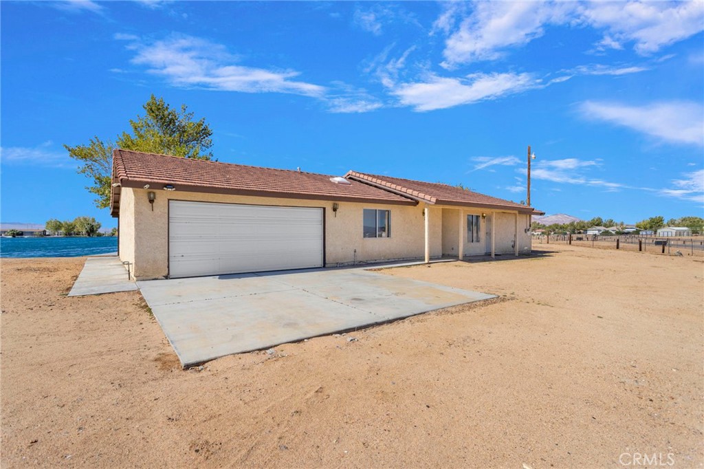 Lakefront Living in Crystal Lakes – Private Community! Welcome to this charming 3-bedroom, 2-bath home perfectly situated on just under an acre in the highly desirable Crystal Lakes community of Newberry Springs. Built in 1991 and offering 1,391 sq. ft. of comfortable living space, this home combines privacy, convenience, and stunning lakefront views. Inside, you’ll find a spacious living area featuring a free-standing wood-burning stove, perfect for cozy evenings. The tile roof adds long-lasting durability, while the attached 2-car garage provides convenience and storage. Outdoors, enjoy a full-length covered patio overlooking the water—ideal for entertaining or simply relaxing. The fenced property also includes its very own private dock, and boat launch giving you direct access to the lake, for fishing , paddle boarding, kayaking, jet skiing, boating in the summer months , during fall and winter months you can enjoy the open desert for off road exploring and the beautiful desert sunsets . Located off the 15 Fwy going to Las Vegas .