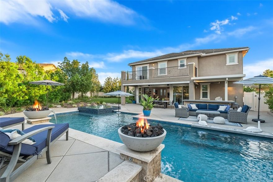 Offering over 4,400 sqft of luxury living with 5 bedrooms and 4.5 bathrooms, this stunning estate sits on the largest lot—over 1/3 acre—at the end of a cul-de-sac in the highly sought-after gated community of Roripaugh Ranch. From the moment you arrive, the curb appeal and custom design set this home apart. Inside, a private office just off the entry provides the ideal work-from-home setup or could easily serve as a 6th bedroom. A formal living room with soaring ceilings and a custom staircase creates an inviting and elegant first impression. Continue down the hall and prepare to be amazed as the home opens into a wide-open great room showcased by 16-foot bi-fold doors that bring the outdoors in. The chef’s dream kitchen features a massive quartz island, KitchenAid range, double ovens, built-in refrigerator, glass-front cabinetry, custom backsplash, butler’s pantry with wine fridge, and a Costco-sized walk-in pantry, all seamlessly connected to the informal dining and living spaces. The great room centers around a beautiful stone fireplace flanked by built-ins, setting the stage for luxury and comfort. Step outside to the entertainer’s paradise: a full-length California room with built-in BBQ overlooks the sparkling pool with raised infinity-edge spa, elevated tanning deck, and over 2,200 sqft of artificial turf with sprinklers for year-round enjoyment. At night, the backyard comes alive with dual fire bowls, a built-in fire pit, and Hollywood hedges creating a private wall of greenery. This home also features an attached second-generation suite with its own exterior entrance, offering a full kitchen with full-size appliances, sitting area, bedroom, bath, and in-room laundry—functioning as a true stand-alone apartment. Upstairs, you’ll find a spacious loft, three secondary bedrooms (one en-suite), and a luxurious primary suite with a private deck overlooking the backyard, spa-like bath with soaking tub, oversized shower, dual sinks, and an expansive walk-in closet. Additional highlights include 16 fully paid solar panels, energy efficiency, and access to Roripaugh Ranch’s country club-style amenities: clubhouse, 24/7 fitness center, pool, spa, tennis, basketball, pickleball, two parks, and private walking trails. This rare estate offers unmatched luxury, space, and lifestyle in one of Temecula’s most desirable communities.
