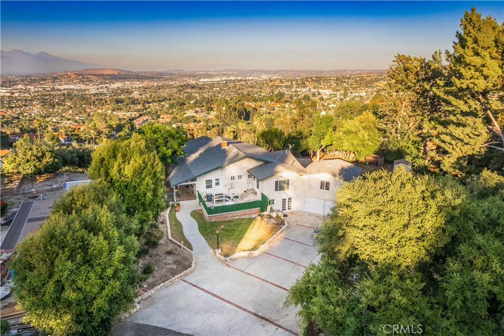 Welcome to 2699 Turnbull Canyon Road, a hidden retreat tucked away on a private road in the hills of Hacienda Heights, in the very sought-after neighborhood of Turnbull Canyon. This home offers something truly special—breathtaking views, privacy, and the comfort of nature all around you. From your deck, you can take in sweeping panoramas of twinkling city lights, snow-dusted mountains in the winter, vibrant sherbet skies at sunset, and dazzling fireworks on the Fourth of July. It’s the kind of view you’ll never tire of, one that makes you pause and feel grateful to call it yours. The home sits on an acre of land with plenty of usable space, giving you both room to grow and the seclusion you desire. Step inside and you’ll find a warm, welcoming floor plan with a formal living room centered around a cozy fireplace, a dining area made for gathering, three comfortable bedrooms, and three bathrooms, plus a separate den that could easily serve as a spacious bedroom. Nearly every window invites the outside in, framing either the sparkling city views or the peaceful canyon that surrounds you. The kitchen and windows have been thoughtfully updated, while the basement provides endless possibilities—whether you dream of extra living space, workshop, or simply a place to store your treasures. The fourth bedroom was once a detached granny studio, now seamlessly connected to the main home, offering flexibility for extended family, guests, or a private primary bedroom with its own bathroom. This property offers a 2 car garage and plenty of Parking for RV, Boat, or recreational toys. Outside, mature trees, natural walking paths, and nearby trails invite you to slow down, breathe, and enjoy the beauty of Turnbull Canyon. And while the setting feels like a world away, you’re still only minutes from schools, shops, markets, and freeway access. Turnbull Canyon is known for its charm—where hillside estates and cozy hideaways come together in one of Hacienda Heights’ most beloved communities. This property is ready for its next chapter, waiting for someone to bring their personal touch and make it their own. 2699 Turnbull Canyon Road isn’t just a home—it’s a sanctuary, a gathering place, and a chance to live surrounded by beauty every single day. A place where every day feels like a retreat.