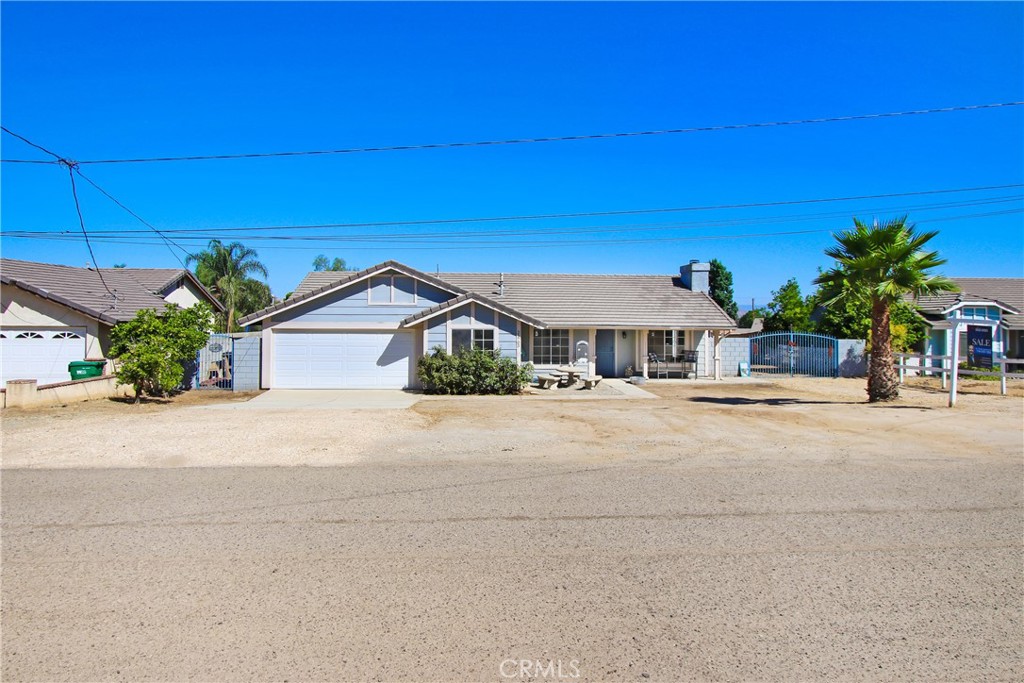 Discover this beautifully remodeled 4-bedroom, 2-bathroom single-family home, perfectly situated on a spacious lot along a private paved street in the charming community of Nuevo, CA. This turnkey residence boasts a bright great room floorplan with high ceilings, recessed LED lighting, and a ceiling fan, complemented by new European Oak-style LVP flooring and large modern baseboards throughout. The expansive kitchen features an oversized island with butcher block counters and bar-top seating, paired with sleek stainless steel appliances, ideal for entertaining. Relax by the fireplace in the inviting family room, designed for comfort and connection. Three well-sized bedrooms include ceiling fans, while the remodeled hall bathroom showcases a white shaker vanity with a white quartz top, new faucet, toilet, light, and mirror. The large primary bedroom offers direct access to the backyard patio and an en-suite bathroom with dual sinks. Additional conveniences include an office area adjacent to the bedrooms, an indoor laundry room with overhead cabinets and a custom iron gate for large RV parking. The fully fenced backyard, complete with a large shed and a solid patio cover spanning the length of the home, offers endless possibilities for livestock, a pool, ADU, or personalized outdoor retreat. It also has room for all of your gardening and farming plans - current plantings include pomelo, tangelo, blood orange, and mylar lemon trees. Nuevo’s small-town vibe and tight-knit community create a welcoming, relaxed environment, with proximity to highly rated award winning schools and amenities in nearby Perris and Moreno Valley. The rural charm of this unincorporated area provides larger lot sizes and a spacious lifestyle, perfect for those seeking room for outdoor activities, hobbies, or a quieter pace of life. Don’t miss this opportunity to own a move-in-ready home with modern upgrades and endless potential in the heart of Nuevo. Schedule a showing today!