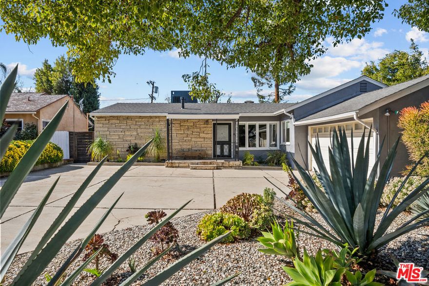 In the heart of Encino, this modern retreat showcases a seamless blend of classic mid-century warmth and fresh contemporary style, perfectly crafted for effortless California living. Step through the entry and into a light-filled living room, where vaulted beamed ceilings and a striking stone fireplace create a sense of warmth and quiet sophistication. Natural light floods the space, accentuating clean architectural lines and an open, airy flow. The layout transitions seamlessly into a spacious family room wrapped in glass, with sliding doors that open directly to the backyard blurring the line between indoor comfort and outdoor living. The kitchen stands as a vibrant focal point, featuring colorful quartz countertops, custom cabinetry, and state-of-the-art stainless steel appliances designed to elevate both everyday living and entertaining.The private primary suite offers a calm and inviting escape, complete with a generous walk-in closet and a beautifully remodeled bath with a frameless glass shower and modern finishes. Two additional bedrooms offer flexibility for guests, a home office, or a creative studio.Step outside to a resort-style backyard designed for true California living  with a heated pool, spa, multiple patios for lounging or dining, and mature privacy landscaping. Whether hosting vibrant gatherings or enjoying a quiet morning by the water, the setting delivers an unmatched sense of ease and lifestyle. Additional highlights include a fully equipped gym, in-unit laundry, central air conditioning, built-ins throughout, and ample parking with both a garage and driveway. Set in one of Encino's most desirable neighborhoods, moments from Ventura Boulevard's premier dining, shopping, and amenities, this home embodies refined design, effortless functionality and elevated California living.