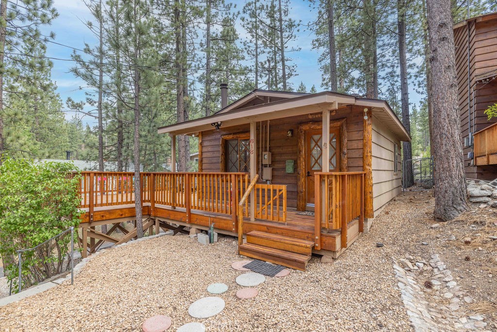This adorable rustic cabin located in a quiet neighborhood of Big Bear City was thoroughly updated in 2014, plus the redwood deck was installed in 2022, and the roof installed in 2024. Upgrades include cedar lap siding and tiger striped log accents at front of home, dual pane windows; knotty Alderwood kitchen cabinets w/ space saving lazy susan, granite countertops, faucets, stainless steel appliances; T&G ceilings and wainscoting throughout, with additional T&G accent walls in each room; log trim doorways and windows; slate flooring in kitchen and bathroom; neutral colored carpet in living and bedrooms; completely remodeled bathroom; 30 gallon electric water heater, full capacity stackable washer and dryer; Vermont Castings wood burning stove with new mantel and extensive use of slate in living room; wood burning stove, new mantel, extensive use of slate, new Williams wall heater, and mirrored closet doors in main bedroom; rustic-style lighting throughout; and asphalt driveway with parking for up to 3 cars, as well as freshly graveled area beyond asphalt that can accommodate 4 additional cars. This property also features a 12’x12’ dry-walled and linoleum floored shed, level area under the deck with enough room to cover two cars from winter weather and sun, space to store a boat or other toys within fenced area of backyard, and 6’x10’ chain link enclosed dog kennel. Offered mostly furnished, this turn-key property is conveniently located 3.3 miles from Snow Summit, 1.9 miles from the lake, and 4.5 miles from the Village, this property is quietly removed from any downtown noise or traffic. This could be a great weekend retreat, vacation rental, or permanent residence with lots of storage.