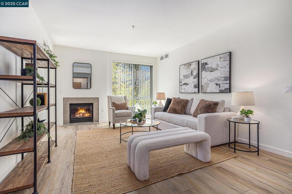 Freshly updated in May 2025 with new HOA approved, luxury vinyl plank flooring, fresh paint, new carpet, some new lights, refurbished bathroom & kitchen grout; this condominium has a fresh contemporary feel. Perched on the third floor, it is flooded with afternoon sunlight and is a peaceful retreat from the bustle of downtown Walnut Creek. The kitchen is a dream—equipped with stone countertops, a Sub-Zero refrigerator, gas range, microwave, and a storage pantry. The inviting living room features a cozy fireplace as its focal point, perfect for relaxing on cold weather evenings at home. A laundry room includes full-size washer and dryer along with additional cabinetry for effortless organization. The primary bedroom features generous closet space and a bathroom with a luxurious soaking tub and a separate walk-in shower. Situated at the MERCER, there is an impressive array of resort-style amenities: a large lap pool, spa, BBQ area, outdoor shower and fireplace, and a clubhouse. Step out and enjoy everything downtown has to offer—top-rated restaurants, boutique shopping, and live performances at the Lesher Center for the Arts, located just across the street. With BART only two blocks away, this location is as convenient as it is vibrant! A refined urban lifestyle awaits.