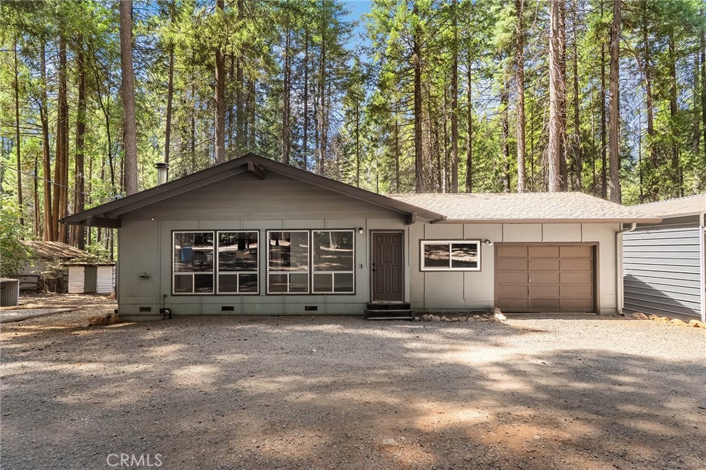 This adorable 2-bedroom, 2-bathroom home sits on a full acre surrounded by beautiful trees, offering privacy and a true sense of mountain living. Located just minutes from Paradise Lake, Little Butte Creek, DeSabla Reservoir, lots of outdoor hiking and horse trails, this property is perfect for those who love the outdoors. The spacious and bright living room greets you with high wood-beamed ceilings, large windows that fill the home with natural light, and a cozy freestanding fireplace. Just off the living room, you’ll find the kitchen featuring high ceilings, a skylight, newer stainless steel appliances, and a peninsula island that provides plenty of counter and prep space. The primary bedroom includes an updated en-suite bathroom. Additional conveniences include indoor laundry and an extra-large 1-car garage with plenty of room for a workshop. Outside, a large carport offers space for an RV, boat, or additional vehicles. With room for animals, gardens, and all your toys, this property combines comfort and functionality while being surrounded by the peace and beauty of nature. Come see what makes this home such a wonderful retreat!