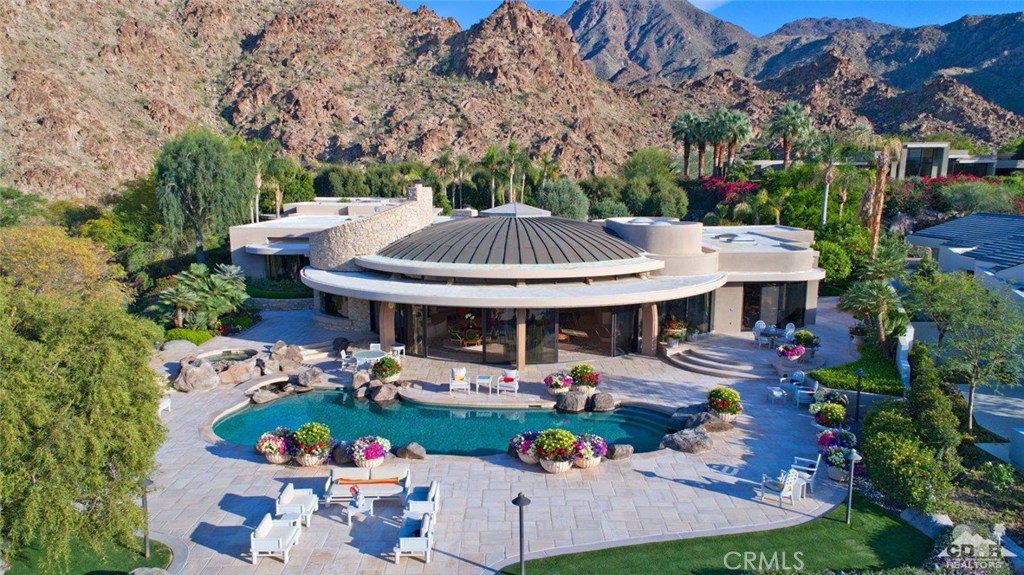This astounding design was created by architect Richard Dodd, and later remodeled for its current owners by architect Tom Jakway. Throughout the journey of this home, each and every artisan held true to its spectacular blueprint of excellence. The interiors of this 11,616 square foot home were masterfully adorned by talented interior designer, Rosemary Rubenstein. The attention to detail given by architects, designers, master craftsmen and the artists of landscape design is supreme. We proudly present this residence for purchase to those discerning buyers who seek a home of perfection and opportunity. Elegantly perched to offer dramatic vistas of the Mountain Course and the rugged mountains that border the desert floor, this home benevolently extends across two lots of nearly an acre and is surrounded by lushly manicured landscape. The outdoor patios extend the entertaining possibilities for family gatherings or a grand soiree.