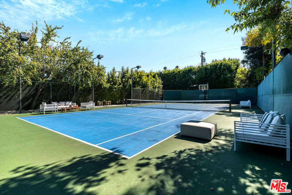 Welcome to this newer remodeled (2024) and expanded one-story Trousdale-inspired home on one of the most desirable blocks in the Beverly Hills Flats. Nestled north of Santa Monica, and mere minutes from the iconic Beverly Hills Hotel and the vibrant heart of Beverly Hills, this exceptional residence combines modern sophistication with classic elegance.This spacious home now boasts five bedroom, five baths, and two additional half baths. The layout offers seamless indoor-outdoor living. A tennis players dream, one of very few available ready to move into tennis court estates. The expansive, almost 19k square foot lot, features a full size tennis court, a pebble-lined deep saltwater pool and jacuzzi with lounging areas, patio with heaters and gas fire pit. Designed for contemporary comfort, the home is equipped with smart features, including Lutron Caseta controlled lighting, integrated speakers, Fleetwood sliding pocket doors, solid doors with Emtek hardware, and dual zoned HVAC. The chef's kitchen is a culinary delight, featuring a large center island, Sub-Zero fridge and freezer, Wolf range, and Miele dishwasher. Skylights throughout bring in natural light. The circular driveway allows for parking for up to 5 cars.