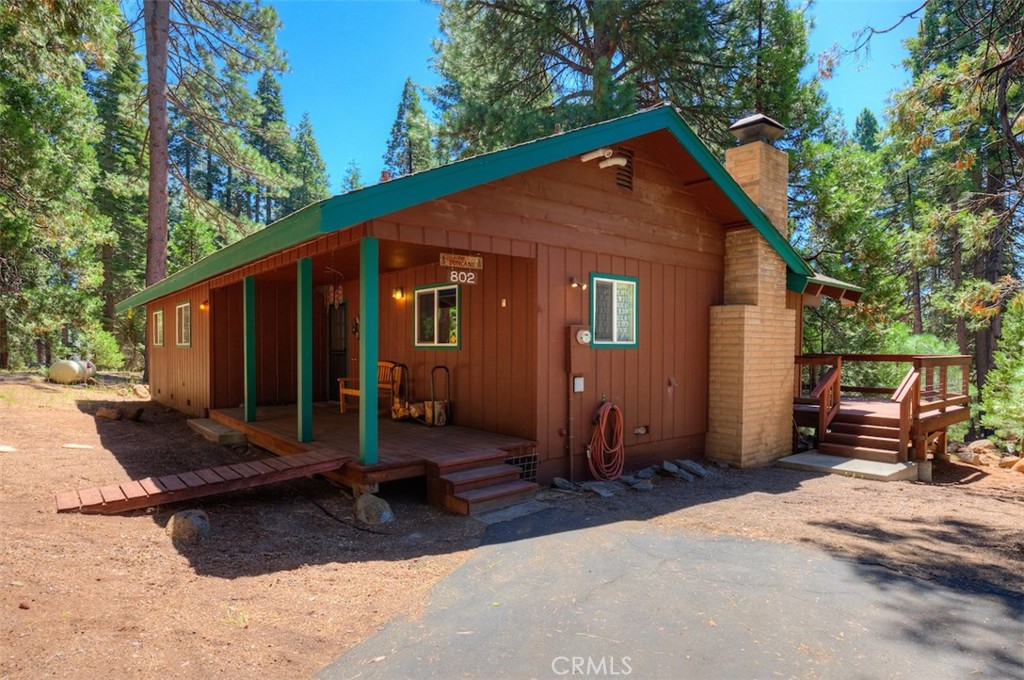 Turn-Key Mountain Retreat in the Heart of Lake Almanor Country Club...discover this beautifully updated 3-bedroom, 2-bath home on a generous .41-acre level lot in a desirable gated community. Perfectly positioned on Clifford Drive, a main thoroughfare plowed regularly for year-round access; this property offers comfort, convenience, and plenty of space for both living and recreation. Upon entry you will be welcomed by the vaulted, wood beam ceiling and wall of picture sized windows drawing the outside in. The home has undergone extensive updates in the past year, including a fully remodeled kitchen w/new cabinets, counters, sink, & disposal; two remodeled bathrooms featuring tile shower & tub enclosures, tile floors, & newer toilets; hardwood floors & molding in the main living areas; newer carpet in all bedrooms; and a newer furnace, stove/oven, washer/dryer. Additional upgrades include a resealed lower driveway, a pumped septic system, and a 915 sq. ft. engineered deck...ready to support a future hot tub. Plenty of storage in the detached 2½-car garage, deep enough to store a 19-foot runabout boat, provides ample room for vehicles and lake toys. The water heater was replaced 5 years ago, and a 6500-watt propane generator (with transfer switch) is included for peace of mind. This property is being sold furnished; including furniture, bedding, appliances, kitchenware, TV, stereo, video game consoles, sporting goods, and more, making it an ideal turn-key rental, vacation getaway, or full-time residence.