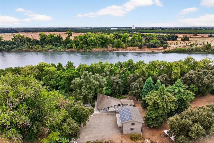 Riverfront Retreat Just 10 Minutes from Chico! Escape to your own private oasis on 3 RIVERFRONT acres, nestled behind Pine Creek Unit of the Sacramento River National Wildlife Refuge. The main home has been beautifully remodeled with new metal roof, electrical, new ductless zoned mini split heating and cooling system, owned solar, imperfect smooth drywall - the seller's haven't overlooked a thing! Enjoy a chef’s kitchen with Wolf range, leather top granite countertops, custom soft-close cabinets, and a custom rock range hood. Gorgeous two-story windows line the living room and add incredible natural light. There are new laminate floors, carpet, recessed lighting, and a striking wood-burning stove with a custom rock hearth create a warm and inviting atmosphere. The master suite is equally impressive with wood-beamed ceilings, wood-paneled accents, and a spacious walk-in closet. The second unit over the garage is also tastefully remodeled with it's own balcony, spacious open concept kitchen and living room, walk-in closet, making it ideal for guests, multi-generational living, or rental income. Outside, you’ll find a brand-new concrete patio, metal fencing, an oversized finished two-car garage, covered storage, 11 different varieties of fruit trees, and mature shade trees that add to the property’s charm. Don't miss this rare opportunity to own a slice of riverfront paradise, just minutes away from town. For full list of upgrades, features and more, call your favorite REALTOR today!