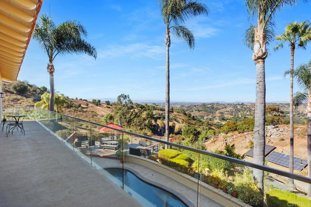 This property offers an expansive layout with approximately 4,750 square feet of living space and five bedrooms and four and a half bathrooms. The home features hardwood flooring throughout, providing a warm and inviting ambiance. The modern kitchen is equipped with high-quality appliances and abundant cabinetry, creating a functional and efficient workspace. The walk-in pantry has extra space to store anything you desire including built-in wine storage. The primary bedroom boasts ample natural light and generously sized windows, allowing for a bright and airy atmosphere. The large en-suite bathroom features a soaking tub and ample storage. Additionally, the property includes a spacious office, providing a dedicated workspace for those who require it. The home's outdoor living spaces are truly remarkable, with a spacious deck and patio offering scenic views and an inviting pool for relaxation. The lush landscaping, including a variety of fruit trees, creates a serene and private oasis. The Avocado Grove has 225 new hybrid trees and an updated irrigation system. The property's 4.42-acre lot provides ample space for various activities and exploration. The home is equipped with a range of eco-friendly features, including 80 solar panels (40 owned and 40 leased), a solar water heater, and a water softener. The property also has two Tesla chargers, making it an ideal choice for those with electric vehicles. The roof is approximately 5 years old, and the heating and air conditioning systems are approximately 3 years old, ensuring the home's efficiency and comfort. The gated community provides an additional layer of security, and the absence of a homeowners association allows for greater flexibility in customizing the property to suit individual preferences. The raised gardens and two chicken coops on the property offer opportunities for those interested in sustainable living and self-sufficiency.
