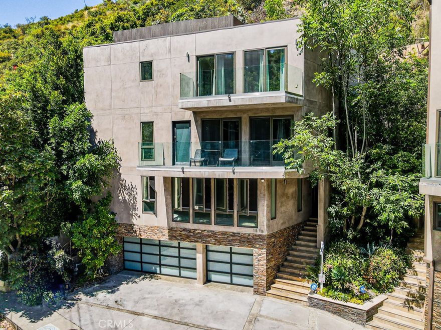This stunning contemporary home is a dream come true for modern entertainers. Located just above Sunset Blvd, this lower Bel Air/Holmby Hills masterpiece features a large rooftop terrace and freestanding units with a 3-car garage for convenient parking. With its architectural flair, this home offers 4020 sq. ft. of luxurious living space. Inside, you'll find three bedroom suites, a den, and six bathrooms. The open layout gives you views from nearly every room, and fills the living space with natural light along with a work-space and sitting area. Each floor can be accessed via an elevator from the 3-car garage. The home also boasts multiple balconies, offering gorgeous canyon views. The open floor plan seamlessly connects the custom kitchen, complete with Viking appliances, walk-in pantry, and quartz counter tops, to the family room. Natural light floods the space, highlighting the stone and hardwood floors, while a large balcony and powder room add even more functionality. State-of-the-art amenities, including automated smart home technology with surround sound throughout and security cameras to ensure that this home is truly an entertainer's dream. Bonus: enclosed garage storage area not included in sq footage. *A few photos have been virtually staged to highlight the home's possibilities and flow.