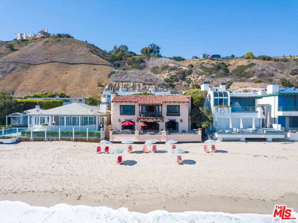 Spectacular two-story Mediterranean-style Villa offering 60' of sandy beach frontage on famed Carbon Beach nicknamed "Billionaires Row," with Catalina, ocean, and white water views from Palos Verdes to the Malibu Pier, and beyond. Located in the heart of Malibu, this elegant home with a lushly landscaped courtyard with Koi pond and stunning entry, offers high ceilings, old world stone floors, and French doors that seamlessly blend that perfect indoor/outdoor Southern California lifestyle. The main level offers a lavish spa, newly renovated chef's kitchen with dual sided fireplace, two-guest suites, entertainer's bar, and a spacious living room with an expansive patio for intimate and lavish entertaining. The entire 2nd floor offers an owner's retreat with high wood ceilings, custom fireplace, lounge area, office, and terrace overlooking the courtyard, beachside balcony, and a large luxurious bath suite. There is a beautiful separate guest cottage with living/media room and ocean views.
