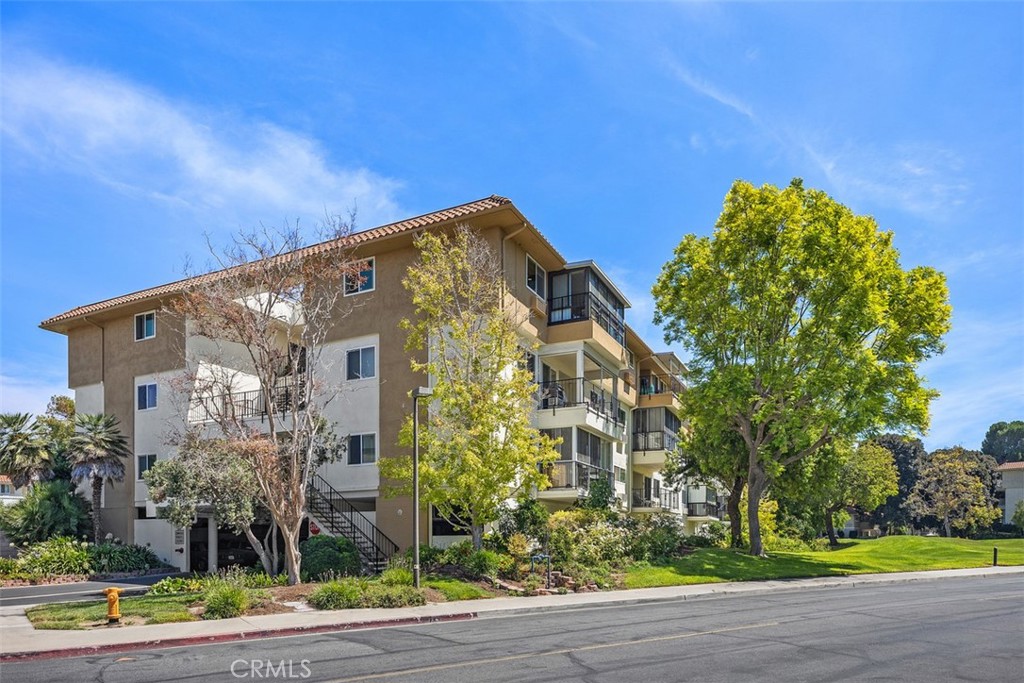 Welcome home to this light-filled 3-bedroom, 2-bath Garden Villa model perched on the top floor of an elevator building with subterranean parking. An expansive, open-air foyer leads to double entry doors and into an expansive living/dining great room wrapped with windows—perfect for entertaining and everyday comfort. Slide the doors open to a generous private balcony and take in sweeping treetop vistas and mountain views from a distance. The fabulous large kitchen offers abundant cabinetry, a nice pantry, recessed lighting, solid-surface counters, and an adjoining breakfast area/flex nook. Both bathrooms are clean and classic: a hall bath with a step-in shower for guests, and a spacious ensuite for the primary bedroom featuring a long dressing vanity and separate tub/shower area. The primary suite also boasts wall-to-wall mirrored wardrobes, while two additional bedrooms provide ideal space for guests, an office, or hobbies. Another great feature is that one Bedroom is located at the opposite end of the Home for privacy, company, or a roommate. Thoughtful touches include double-pane windows, crown molding, tile floors in the entry/kitchen/dining, and plush carpet in the living spaces and bedrooms. Lush landscaped grounds, mature trees, and nearby fairways set a tranquil resort-style tone, and the large balcony is perfect for outdoor dining, birdwatching, or evening sunsets. Tucked inside Laguna Woods Village, Orange County’s premier 55+ community, you’ll enjoy resort-style amenities including a 27-hole championship golf course plus a 9-hole walking course, tennis & pickleball, seven clubhouses, five pools/spas, two fitness centers, a performing arts theater, equestrian and garden centers, miles of walking paths, and 250+ social clubs. With 24-hour gated security, convenient community transportation, and a location just minutes to shopping, dining, world-class medical, and the beaches of Laguna—this is the carefree SoCal lifestyle you’ve been waiting for. Also, there is a very economical RV storage area to park your RV. Country Club Living is at its BEST and just approximately 6 miles from beautiful Laguna Beach! "SEE VIRTUAL VIDEO AND 3D TOUR"