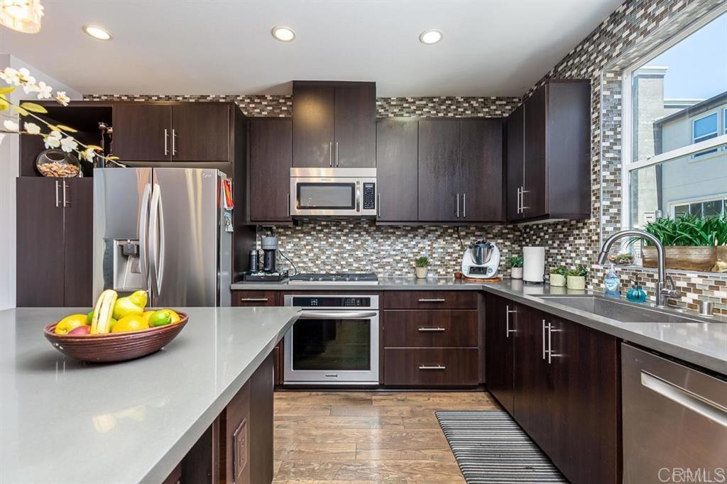 Located in the award-winning master-planned community of Civita in Mission Valley, this beautifully upgraded 3 bed, 3.5 bath townhome blends modern luxury with stylish, loft-inspired design. The open-concept layout features soaring ceilings, designer finishes, distressed wood flooring, and natural light streaming through oversized windows with power shades. The entry-level offers a private bedroom and full bath with its own patio, perfect for guests, a home office, or multigenerational living. Upstairs, the chef’s kitchen shines with Caesarstone counters, espresso cabinetry, high-end appliances, and a spacious island that seamlessly connects to the living and dining areas. Two balconies provide added outdoor living, ideal for relaxing or entertaining. Each bedroom includes its own walk-in closet, and the spacious primary suite offers a tranquil retreat area. A unique highlight: the rare sky loft; an elevated space that only select units have, featuring a luxurious in-suite bathroom with double sinks, a walk-in closet, and views of Mission Valley. Additional features include a tankless water heater, an attached 2-car garage, and smart upgrades throughout. Residents of Origen enjoy exclusive access to a private pool and spa, as well as the renowned Civita Recreation Center: offering two resort-style pools, a full gym, cabanas, BBQ areas, fire pits, event space, chef’s kitchen, and more. You’re also steps away from Civita Park: 14 acres of green space, splash pad, playgrounds, dog parks, sports courts, and walking trails. Enjoy the convenience of walkable shopping, dining, and the brand-new Nipaquay Elementary School, plus quick access to the trolley and major freeways.