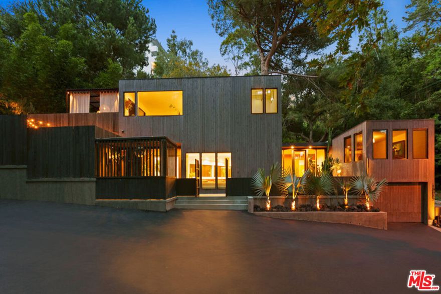 Journey into tranquility and serenity at this hidden gem nestled in the canyons of Beverly Hills, sited at the foothills of the Santa Monica mountains. Meticulously renovated in 2017 by globally acclaimed architect Alex Pettas, AIA formerly of Marmol Radziner, this Wabi-Sabi inspired residence seamlessly blends nature with refined living. Experience the harmonious connection with the outdoors through abundant indoor-outdoor living spaces. Admire the solid white oak floors that grace the interior. Feast on the gourmet kitchen, adorned with its waterfall edge Carrera marble. Bask in wall-to-wall windows while enjoying views of a rare and tropical plant collection. The focal point of the dining room, a sculptural chandelier from the prestigious Italian design house Venice M, creates an exquisite atmosphere. Adjacent is a wine room, leading to a spacious patio perfect for enchanting alfresco dining amidst the alluring scent of trailing jasmine. Beyond the living room, the first floor offers two bedrooms and a bathroom showcasing Ann Saks tile and FRANKE fixtures, setting the tone for luxurious living. Ascend the steel spiral staircase to discover the primary suite, featuring two walls of custom oak closets that artfully disappear, embodying a simple yet elegant aesthetic. Unwind in the sophisticated soaker tub, complete with Airbath system jets and finished with fixtures by esteemed designer Jason Wu. The bedroom, with panoramic garden views, beckons relaxation and draws the eye out through accordion-style sliding glass doors. Once fully opened, immerse yourself in the expansive deck crafted from Ipe wood, complete with a private outdoor shower. Explore the permaculture-designed garden, where mature fruit trees, including citrus, apricot, plum, taro, and assorted berries, thrive. The western portion of the lush tropical landscape, bordered by giant timber bamboo, provides privacy and hosts an Alaskan white oak Japanese Ofuro tub designed by renowned artisan Andrew Brant. This natural sanctuary is the pinnacle of refined living that's seamlessly integrated with nature. Fully-furnished. Small pets okay.