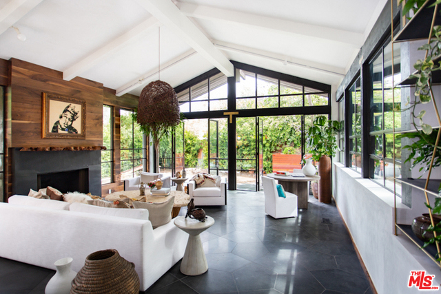 Kim Gordon brings her celebrated sophisticated bohemian style to the treetops of Santa Monica Canyon. Gordon's homes are highly prized for their cultivated and warm modern vibe, where privacy and love permeate each special nook. This stunning home sits on .35 acres and boasts 5 bedrooms, 6 1/2 bathrooms, 3 wood burning fireplaces, terraces, a pool, and lush gardens. Beautiful interior features include limestone and walnut floors, white plaster walls, steel doors, lofty ceilings, and unsurpassed custom details everywhere. The exciting chef's kitchen with brass and curved wood is nestled with warm black and brown marble, Wolf/Sub-Zero appliances, a convenient pantry, and a delightful coffee/wine station. The bespoke counter bar with little pop out drawers on all sides is a must see! The formal living room is framed by a giant wood-burning fireplace and has stunning cathedral ceilings and gorgeous corner views of the garden. Gordon's infamous attention-to-detail is fully realized!