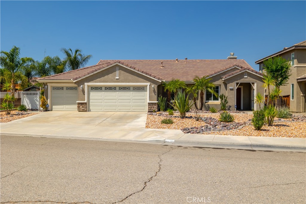This stunning single-story home offers 3 bedrooms, 2 bathrooms, and a versatile office/bonus room. Built in 2005, it has been beautifully updated inside and out, blending comfort, efficiency, and style.
The front yard is a true masterpiece. Designed with drought-tolerant desert landscaping, it features a decorative rock “river” accented with shimmering blue fire glass. At night, custom lighting creates a dramatic, glowing effect that highlights the riverbed and delivers show-stopping curb appeal.
Step inside to soaring ceilings, fresh designer paint, and wide-plank luxury vinyl flooring in neutral tones. The kitchen boasts sleek black quartz countertops, a spacious center island with bar seating, custom tile backsplash, dual pantries with decorative glass doors, and abundant cabinetry. It flows seamlessly into the inviting family room with a cozy gas fireplace and the dining area with its rustic chandelier.
The private primary suite is generously sized with backyard access and space for a sitting area. The primary bath has been remodeled with quartz counters, dual sinks, a soaking tub, a separate walk-in shower, and a large walk-in closet. Secondary bedrooms are roomy and bright, featuring recessed lighting with dimmers. Both bathrooms are elegantly updated with modern finishes, decorative mirrors, and soft-close cabinetry.
Additional highlights include plantation shutters, a whole-house fan, upgraded fixtures, new baseboards, and a stylish laundry room with custom cabinetry and a frosted glass door. The finished 3-car garage is equally impressive with recessed lighting, a Level 2 EV charger, an additional whole house fan to keep the garage nice and cool, and a whole-home water filtration and softener system.
The backyard offers the perfect retreat with an extended concrete patio, Alumawood cover, lush artificial turf, and raised flower beds — all designed for low-maintenance enjoyment.
This home combines eye-catching curb appeal with thoughtful upgrades throughout — a truly unique property you’ll be proud to call home.