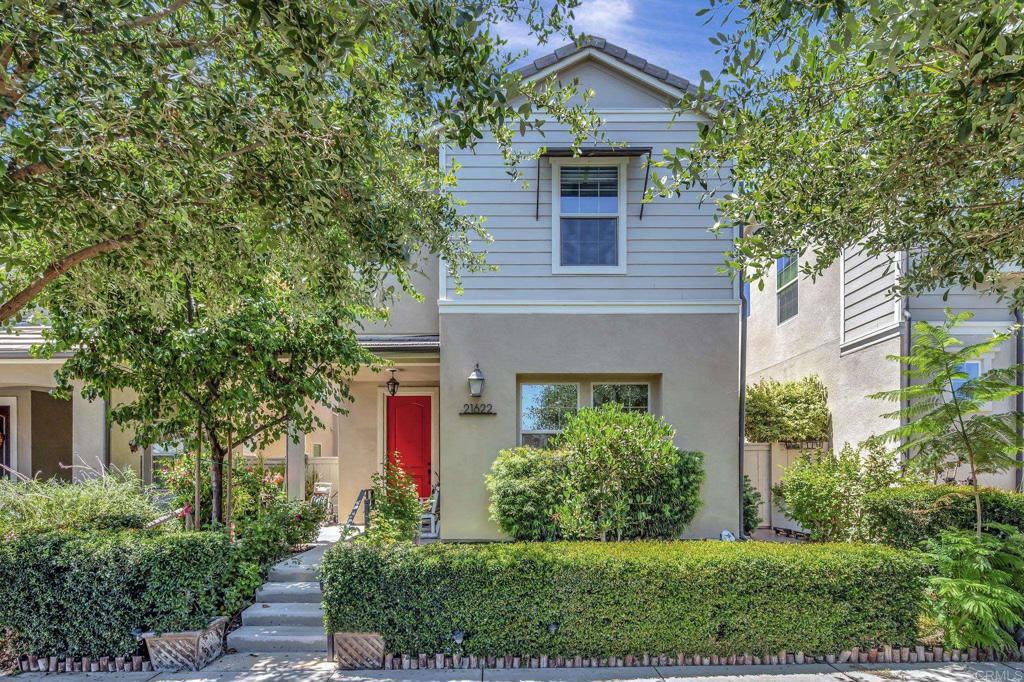 This bright Lusitano neighborhood home in Harmony Grove Village features an open kitchen, custom finishes throughout, a spacious primary suite with wood-accented details, owned solar, tankless water heater, and a low-maintenance backyard with covered patio. The kitchen features tile flooring, white cabinetry, granite countertops, a large center island with seating, stainless steel appliances, under cabinet lighting, full custom tile backsplash, recessed lighting, custom pendant lights, and a built-in pull-out trash receptacle. The bright dining area is surrounded by windows and flows into the open living room with natural light from multiple windows. Sliding glass doors lead to the private backyard, creating a seamless connection between indoor and outdoor spaces. The spacious primary bedroom features a light wood-paneled accent wall, beautifully contrasted by rich, dark wood crown molding and exposed wood ceiling beams. Several windows and recessed lighting make the space feel bright and inviting. The en-suite bathroom provides dual sinks with custom tile backsplash, a walk-in shower, and ample space for daily comfort. A lower-level nook with cabinet storage connects the kitchen to the two-car garage. The downstairs powder room showcases a pedestal sink against a striking mosaic tile feature wall, with picture frame wainscoting and custom tile flooring. Upstairs, the landing features a built-in cabinet storage beneath a sunlit window. The laundry room includes upper cabinet storage and a folding station with a custom tile backsplash. Additional upstairs bedrooms are filled with natural light and include recessed lighting and sliding closet doors. A connected bathroom between the two secondary bedrooms includes dual sinks, a wall-to-wall mirror, custom tile backsplash, white cabinetry, and tub/shower. The low-maintenance backyard includes a covered patio ideal for entertaining or relaxing, with easy access from the main living areas. Harmony Grove Village is a master planned community with gorgeous mountain ridgeline views, multipurpose trails, gated pool for homeowners, multiple private parks and huge 4th of July Park (open to the public). The Grove is the perfect place to enjoy the outdoors- it includes the pool, jacuzzi, wading pool, barbeques, shaded tables, play structure and a covered lounge area with outdoor furniture and fireplace.