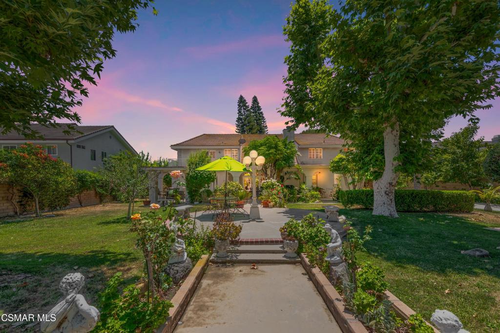 At the far end of a quiet cul-de-sac, where privacy meets grandeur, this estate delivers scale, light, and a sense of permanence you simply can't build today.Created in 1988 by its original owner, every detail was designed for substance and a life well-lived. Step through double doors into a formal living room that feels almost ceremonial--towering ceilings, walls of glass, and a sense of openness you rarely find. The dining room easily hosts fourteen. The family room? Generous enough for everyone you know, anchored by a built-in bar more at home in a country club than a private residence. Downstairs, a guest suite enjoys its own backyard access, and a dedicated sewing/craft room adds purpose and charm.Upstairs, all four bedrooms are true suites, each with a walk-in closet and a bath large enough to feel indulgent. The primary spans its own wing with a sitting room, fireplace, and a bonus space ready to be a nursery, yoga studio, or enviable second closet.Nearly half an acre of flat, sun-washed grounds surround the home--complete with mature fruit trees, hidden garden nooks, and room for gatherings that number in the hundreds. There's RV access, plus a detached workshop with potential for an ADU or creative studio.Here, the scale matches the setting. Minutes from Porter Ranch, hiking trails, and The Vineyards' dining scene--yet perfectly tucked away in one of the Valley's most private pockets.