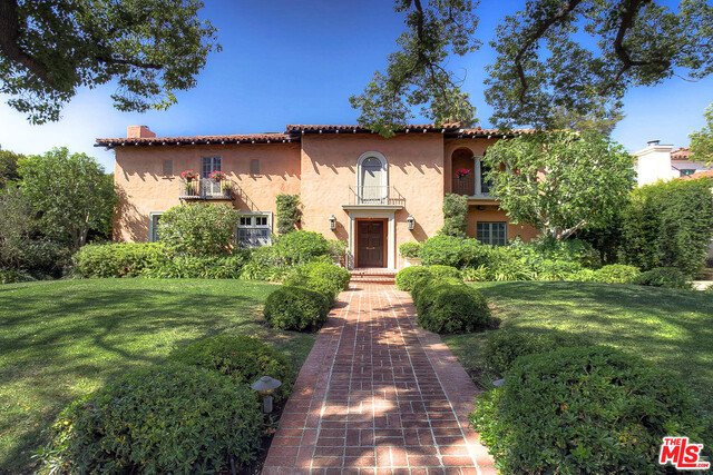 This classic Beverly Hills Spanish home, on over 16,500 sqft, welcomes you into a 2-story grand entryway with original Saltillo tiles and a beautiful wrought iron staircase. Off the foyer sit a stately formal dining room and an elegant living room with a wood-burning fireplace and original architectural details, including stained glass windows and a stenciled wood beam ceiling. The separate breakfast room and generously sized family room with wet bar open to the veranda and offer expansive views of the garden. The picturesque yard includes a spacious seating area, grass, pool, and cabana with ¾ bath. Upstairs sits a master suite, 3 additional bedrooms and an enclosed sun-porch. There is a separate maid's quarters downstairs with a full bath. Known for its beautiful trees, expansive lots, and rich history, Maple Drive offers discerning clientele a coveted location in the Beverly Hills Flats. Don't miss the opportunity to own the home of your dreams on this highly sought-after street!
