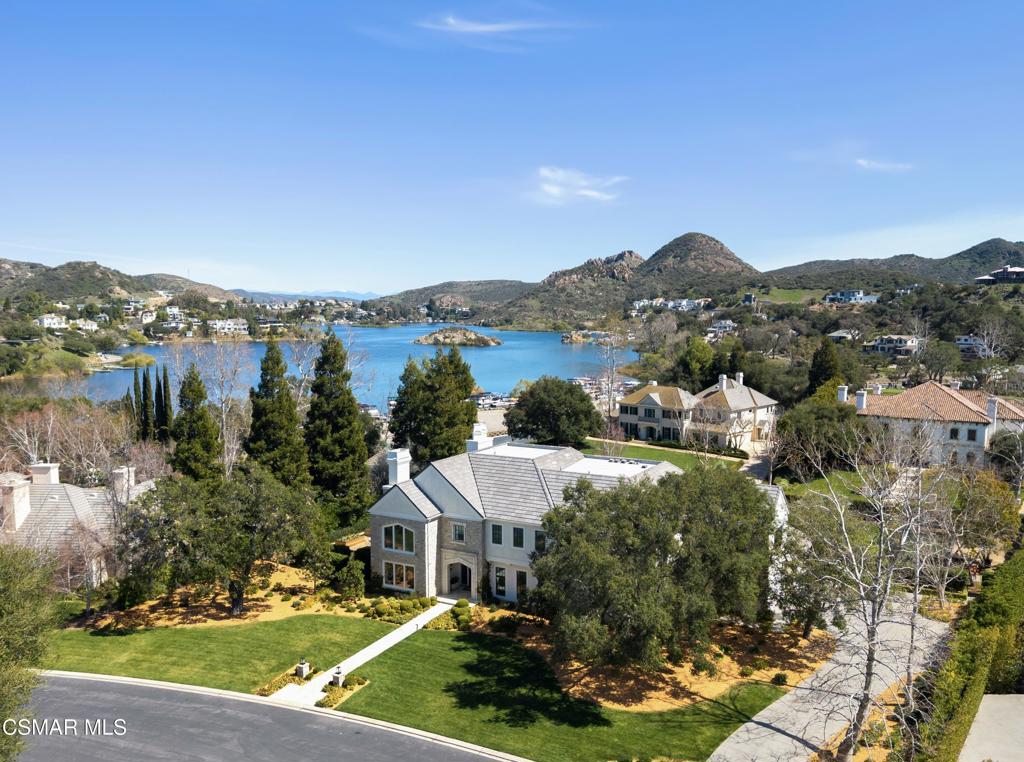 This stunningly reimagined estate seamlessly blends classic sophistication with fresh, contemporary design, creating a truly unique masterpiece--unlike anything else in Sherwood. A rare opportunity to own one of the most exquisite and impeccably crafted properties in prestigious Sherwood Country Club, set on a premier flat acre with breathtaking lake and mountain views. Spanning approximately 8,383 sq. ft., this home is designed for luxury and comfort, featuring an incredible floor plan with a unique layout of six en-suite bedrooms, including two conveniently located downstairs, and seven baths. The gourmet kitchen flows seamlessly into a spacious family room, complemented by a library/office, a formal living room, and a spectacular dining room that exudes elevated sophistication and modern flair. Upstairs, a secondary family/media room offers the perfect space for entertainment. The sumptuous primary suite is a true retreat, featuring a cozy fireplace, a private balcony with lake views, and a salon-style shampoo station in the luxurious primary bath. Pocket doors open to the ultimate outdoor oasis, featuring covered loggias, a state-of-the-art outdoor living room with an entertainment center and fireplace, an outdoor kitchen & BBQ, a sparkling pool & spa, and batting cage. In addition, the backyard showcases raised planters and a serene lavender haven, offering a tranquil and lush environment. This is California living at its finest, offering panoramic views of Sherwood's stunning landscape in an estate remodeled to absolute perfection!