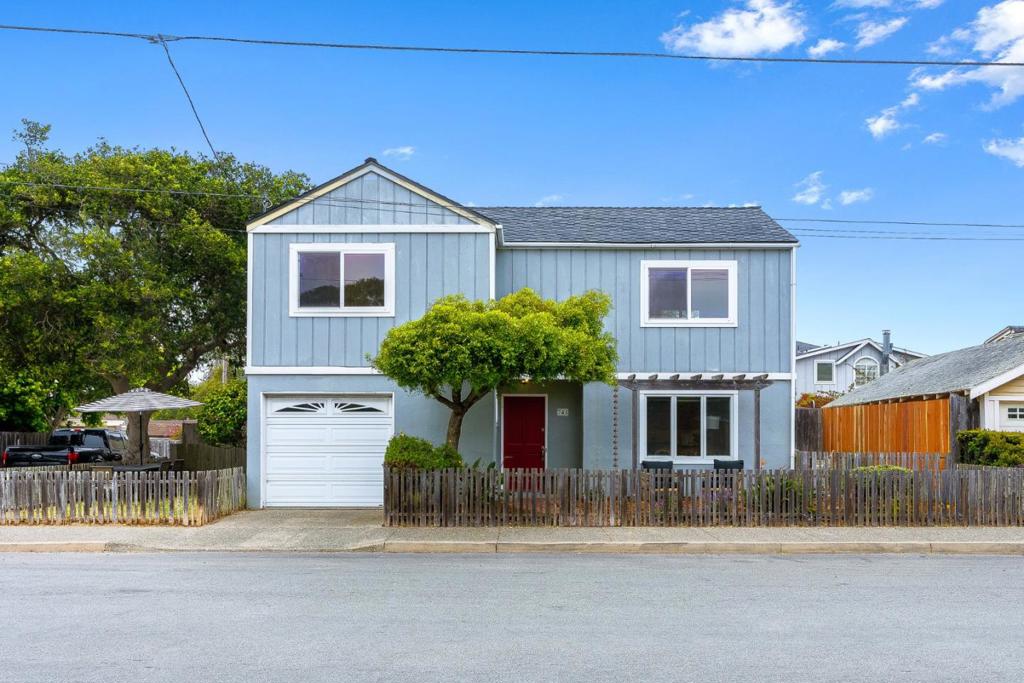 A red door. A warm welcome. And a home that instantly feels like it belongs to you. Tucked into one of Pacific Grove's most beloved neighborhoods, this contemporary coastal retreat invites you in with light, space, and a quiet sense of ease. Step inside and you're greeted by a sun-drenched great room that seamlessly blends living, dining, and gathering spaces perfect for everything from slow Sunday mornings to impromptu dinner parties. The heart of the home is a chef's kitchen that balances function with style. Corian countertops, rich cherry cabinetry, and stainless steel appliances set the stage for everything from pancake breakfasts to evening wine with friends. Upstairs, three spacious bedrooms offer a peaceful escape, bathed in natural light and thoughtfully positioned for privacy. A beautiful full bath serves the sleeping quarters, while a half bath downstairs adds convenience for guests. With its walkability to schools, the coastline, and downtown, this is one of the great locations on the entire Monterey Peninsula. Come see how life feels here. In Pacific Grove, charm isn't just a word, it's a way of living.