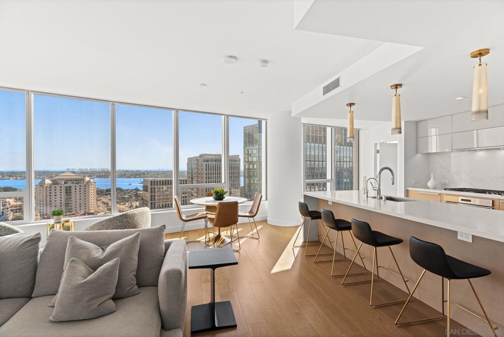 Experience resort-style living high above the San Diego waterfront in this stunning two-bedroom, two-bath residence at Pacific Gate, downtown’s most iconic luxury high-rise. Framed by walls of glass, this highly sought-after southwest corner floor plan captures panoramic views of the Pacific Ocean, San Diego Bay, Coronado Bridge, and the city skyline. Thoughtfully designed and upgraded, this home features custom built-ins throughout including a sleek living room media center, a bespoke walk-in closet and vanity in the primary suite, and a versatile office station with a pull-out Murphy bed in the guest room. The open-concept kitchen showcases top-of-the-line Wolf, Miele, and Sub-Zero appliances, complemented by rich finishes and designer details. Step onto your expansive private terrace and take in the breathtaking coastal vistas, perfect for morning coffee or evening sunsets. The split-bedroom layout provides optimal privacy and functionality, ideal for hosting guests or working from home. As a resident of Pacific Gate, you’ll enjoy an unparalleled collection of amenities including a private luxury boat share, car fleet, 24-hour concierge, guest suite, pool terrace with cabanas, state-of-the-art fitness center, residents lounge, screening room, and on-site restaurant. Live moments from the waterfront, Seaport Village, and the city’s finest dining and entertainment. The first all-glass Super Prime residential tower in San Diego offers an unprecedented waterfront lifestyle with sky-high amenities and picture-postcard views. Directly overlooking the waterfront, the 41-story tower contains an exclusive offering of homes designed by Hirsch Bedner Associates. Renowned New York-based architectural firm Kohn Pedersen Fox (KPF) created a landmark that reimaged the San Diego skyline. The custom-engineered glass walls dynamically reflect the hues of the sky and the Pacific Ocean. Pacific Gate has evolved the San Diego skyline and represents the future of the city. The building is comprised of two-nested curved glass towers that rise as a single column from a three-story ground floor retail podium on the north and west sides of the tower. Because of the building’s curves and exterior glass, Pacific Gate offers a striking viewing experience from every vantage point. Residents arrive home to a beautifully landscaped motor court with a private luxury car fleet, which leads to a double-height lobby with a 24-hour concierge and porter services. Two levels of amenities boast a residents lounge ideal for events and everyday use, the fitness center contains an extensive range of state-of-the-art equipment. Adjacent to the fitness center is the steam and sauna retreats that open up to the fourth-floor pool terrace fitted with poolside cabanas and glass surround.
